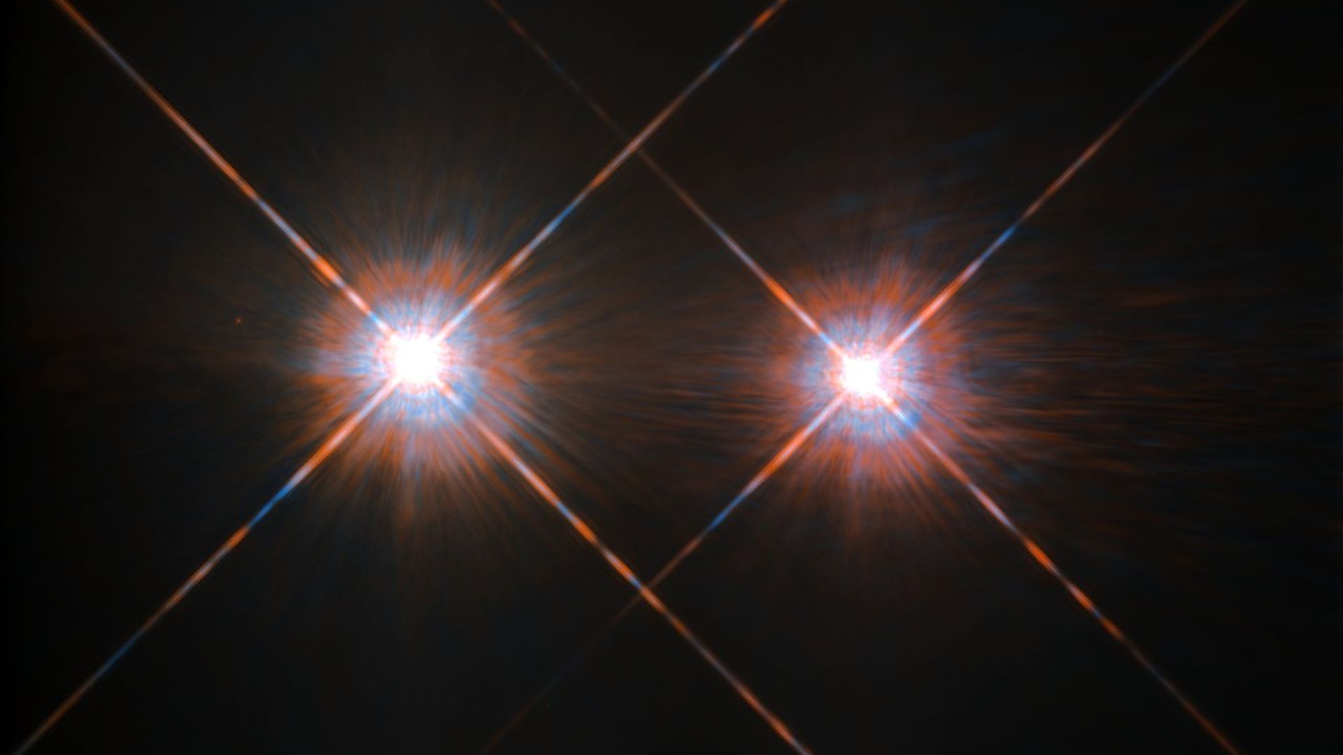 Two bright twin stars shine, with rays shooting out of them against the blackness of space