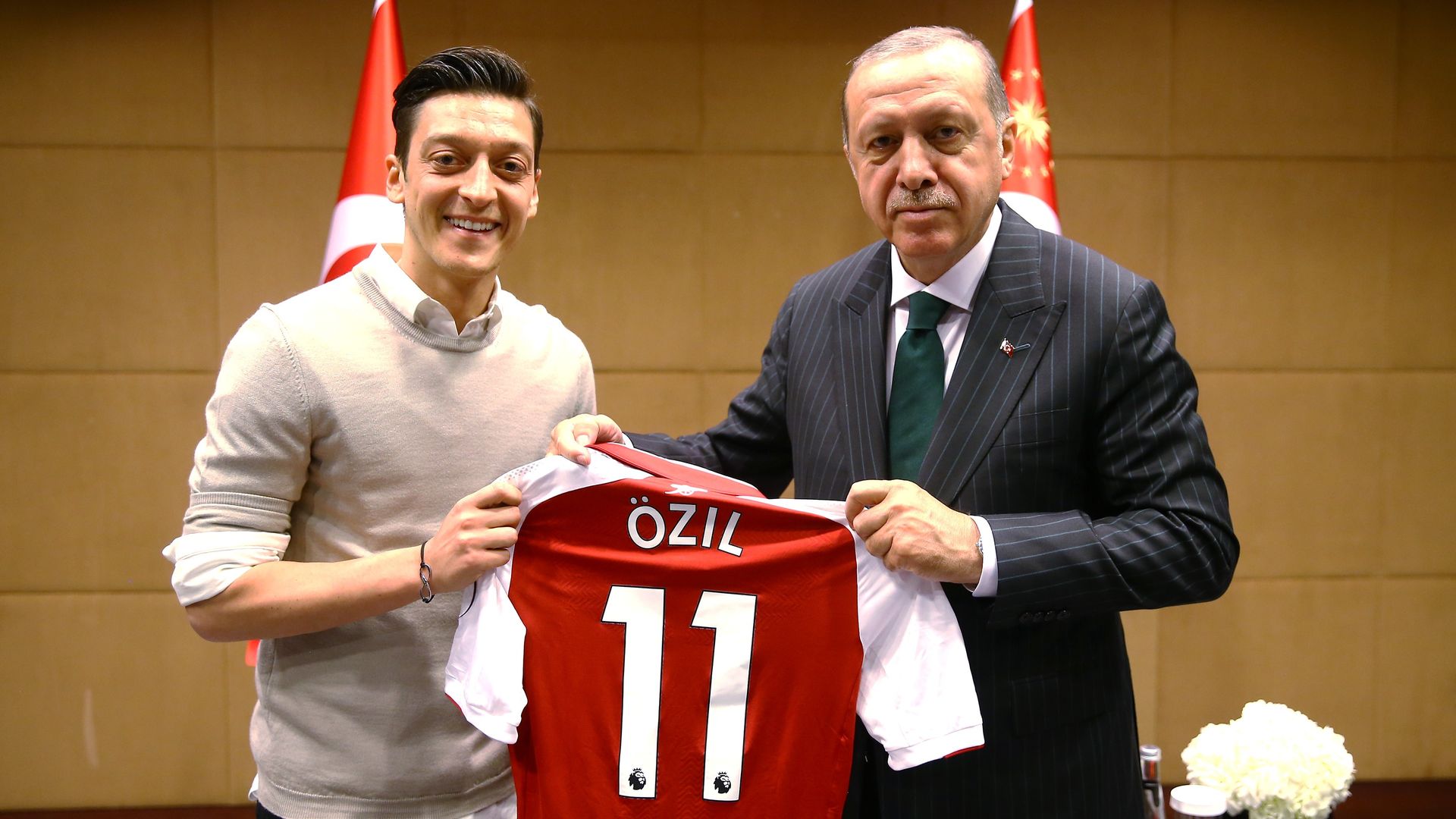 Soccer player Mesut Ozil holding an Arsenal jersey with Turkey's President Erdogan