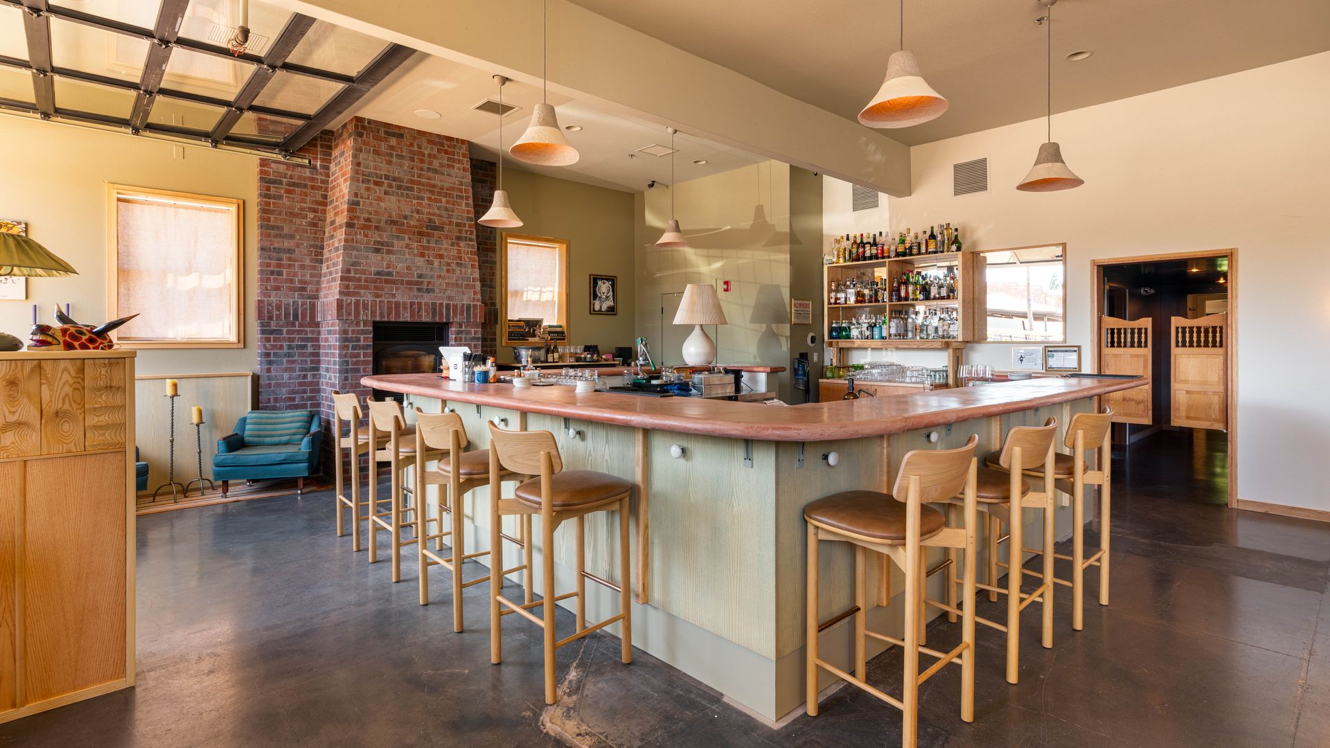 A photo of a bar top aside a brick fireplace in a dining setting.