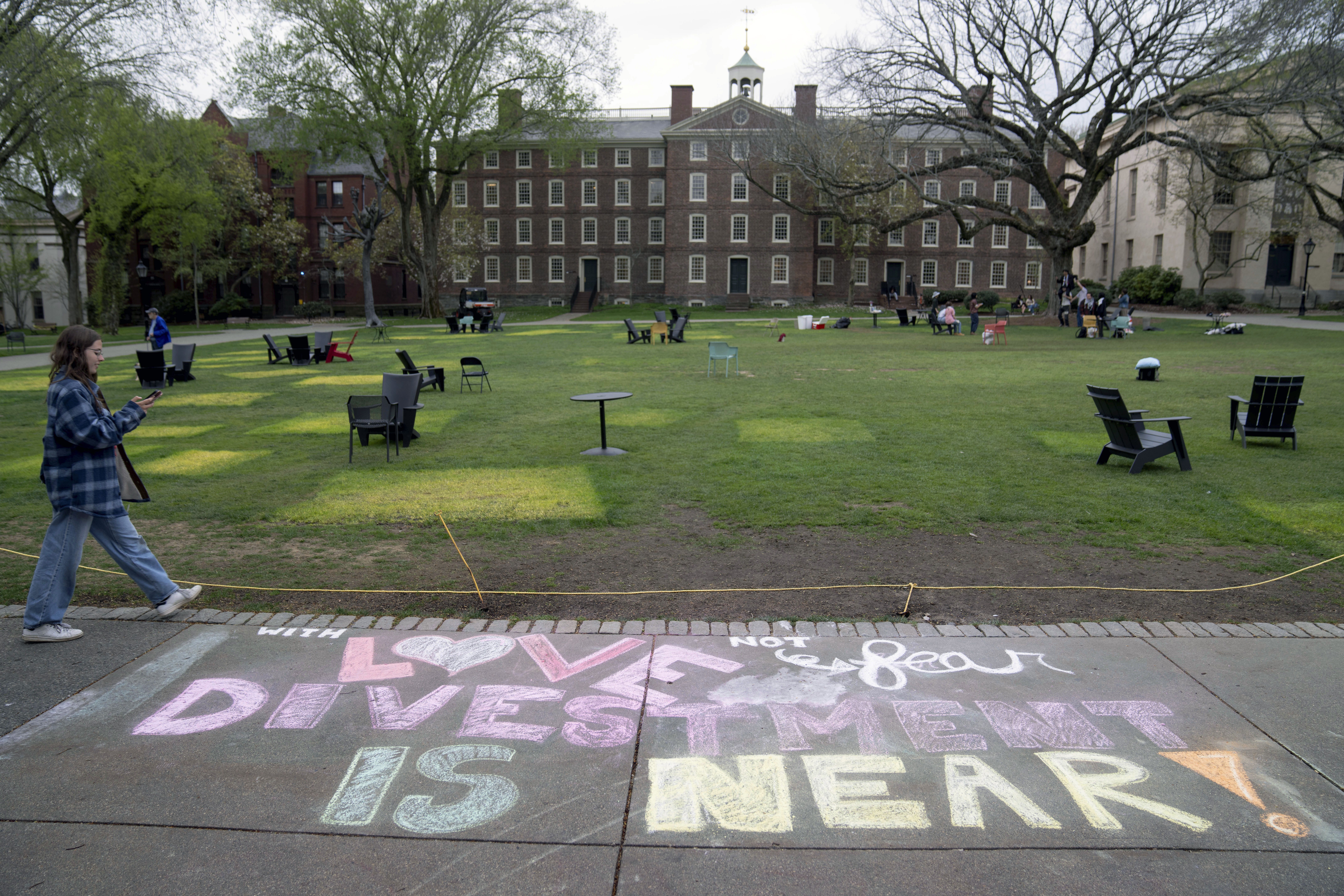 A message in chalk decorates a sidewalk on Tuesday after protesters took down their tents at Brown University.