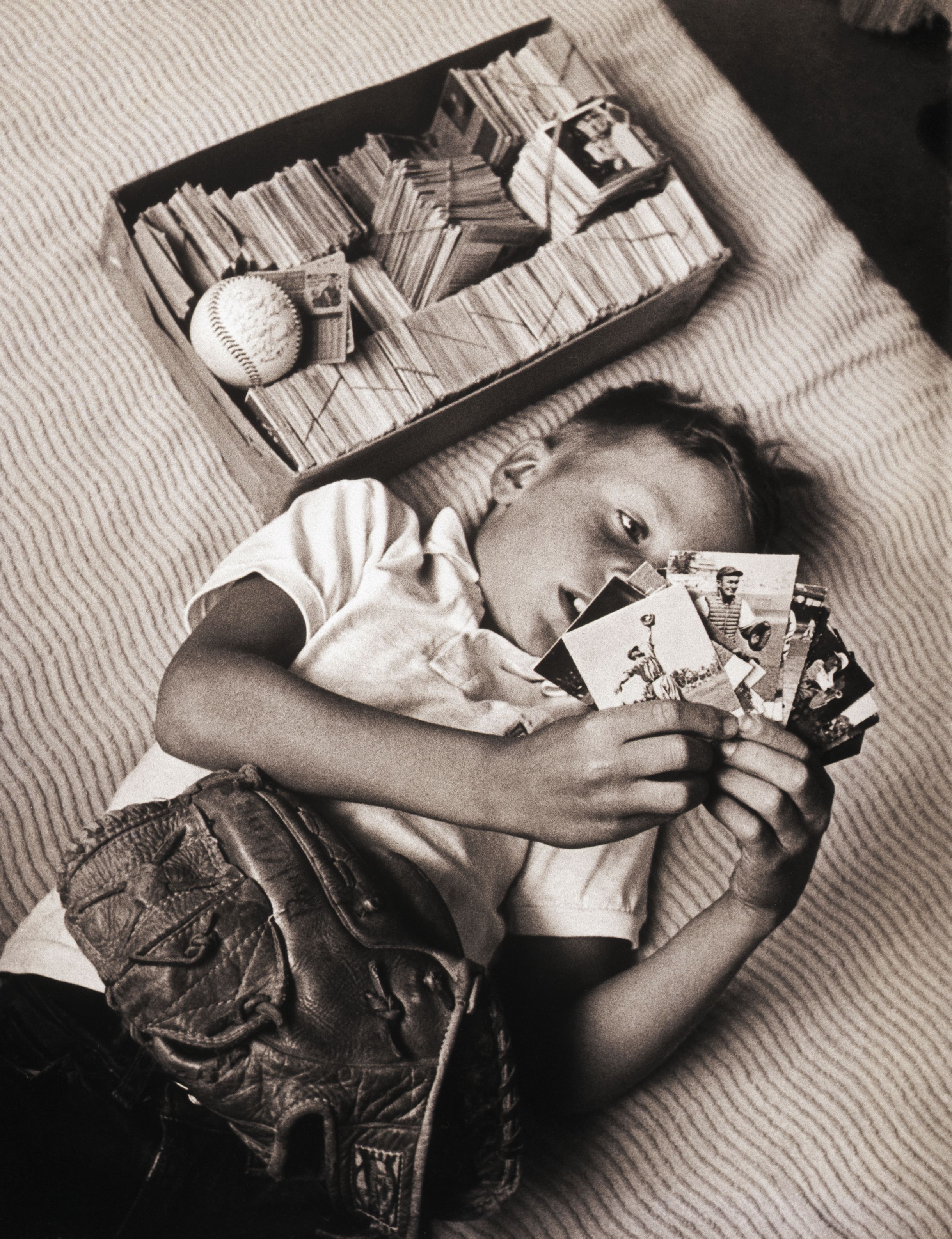 A young baseball fan looks through his Topps collection in 1965.