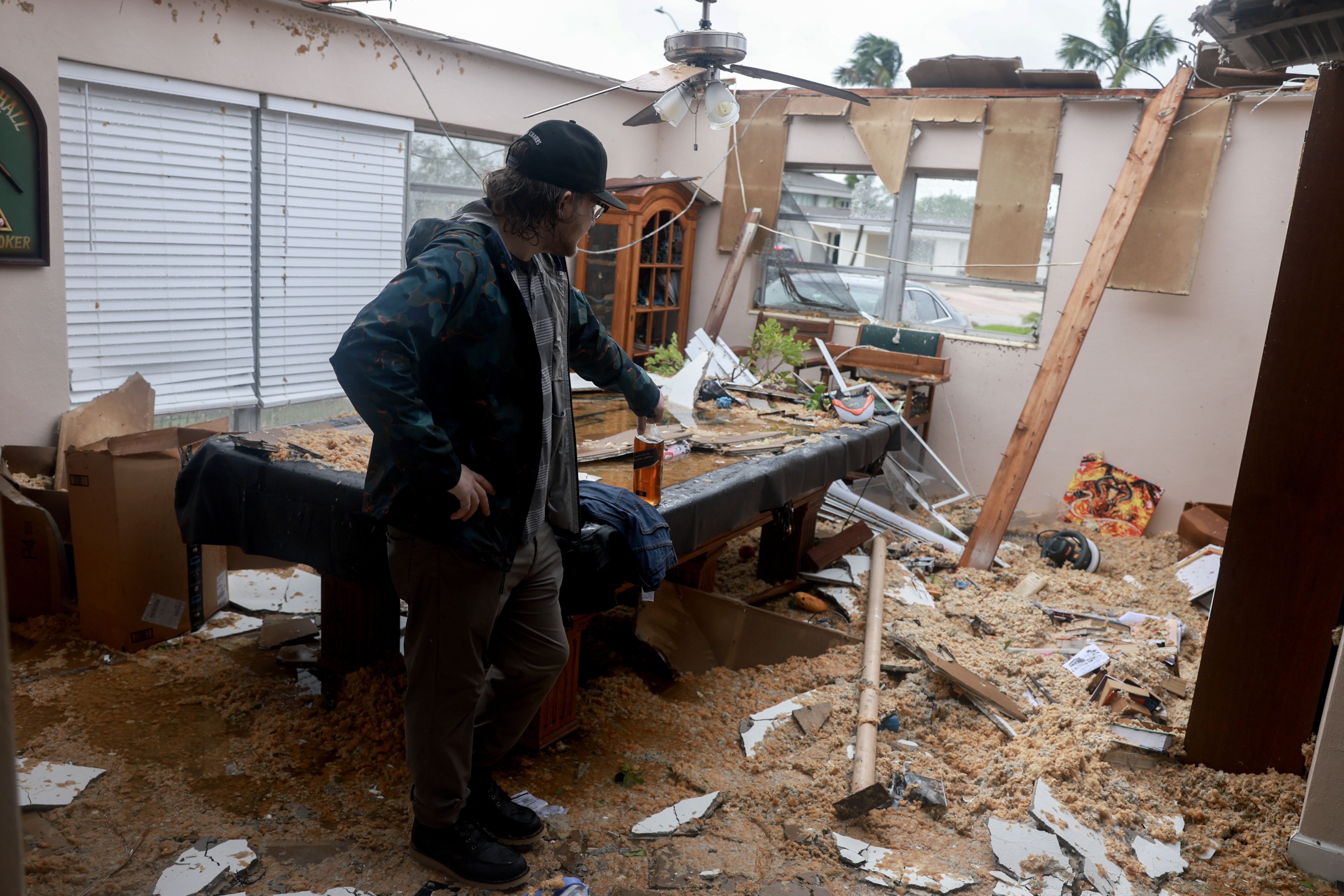 Connor Ferran surveys what is left after what appeared to be a tornado tore the roof off of his home before Hurricane Milton's arrival on October 09, 2024, in Fort Myers, Florida. He said he had just had the roof replaced two years after Hurricane Ian had damaged it. People are preparing for the sto