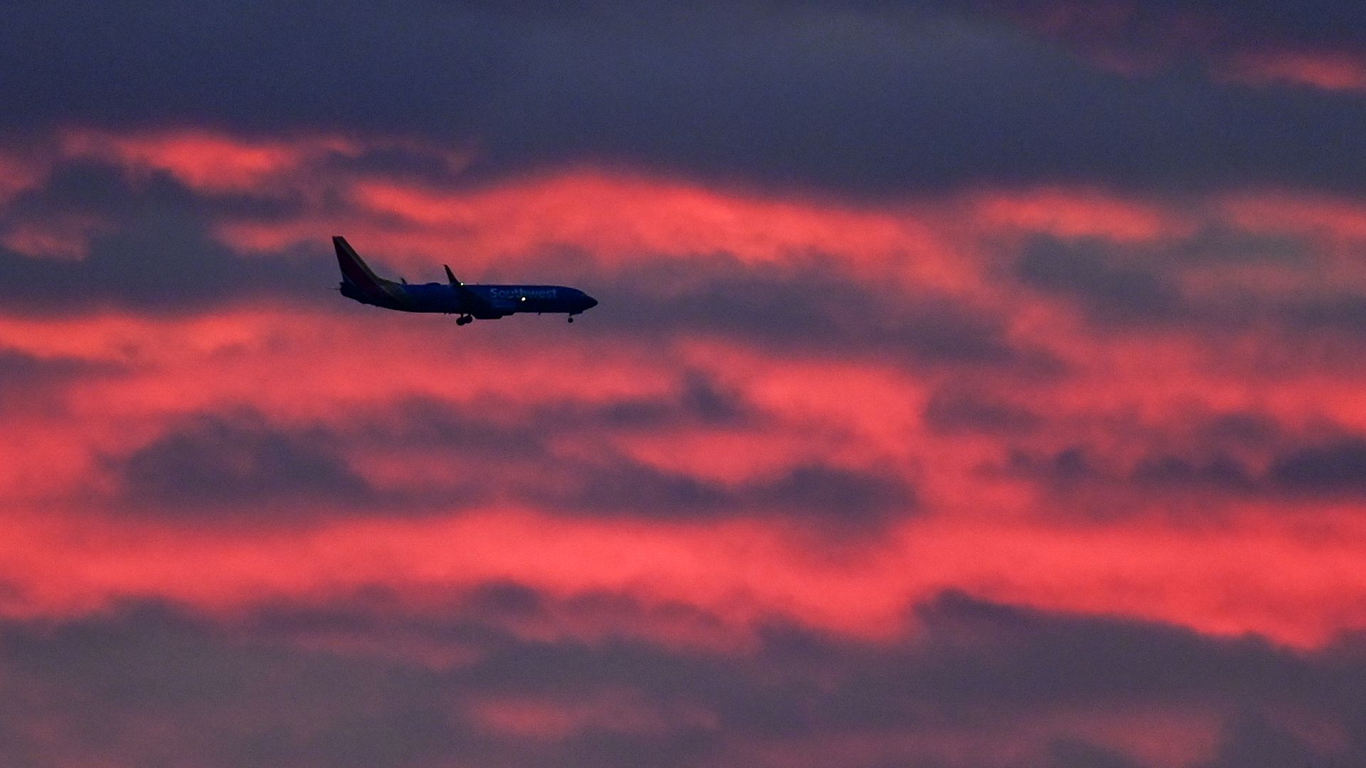 Image of a plane landing at sunset