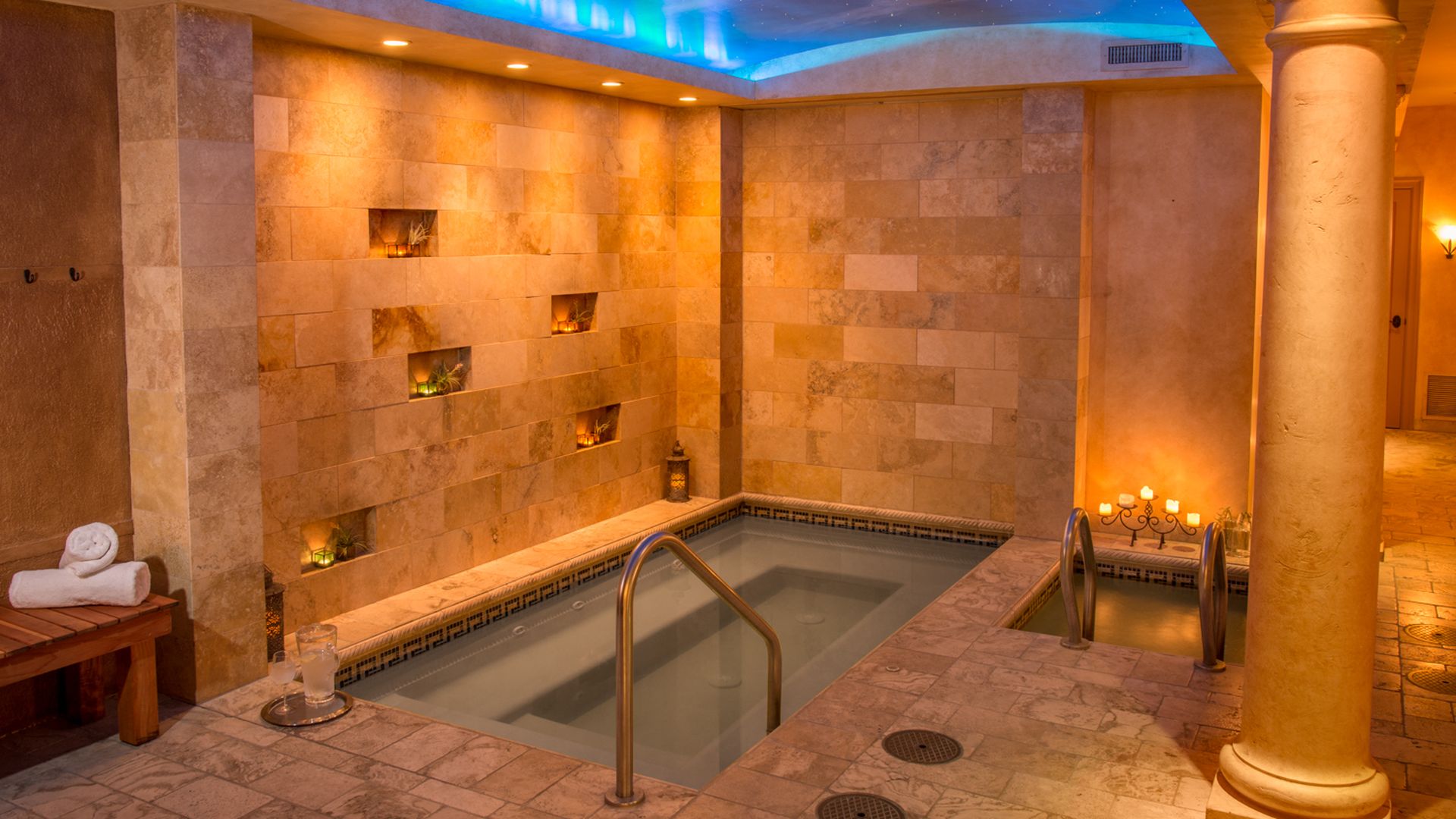 A photo of a stone tiled spa with a soaking pool. 