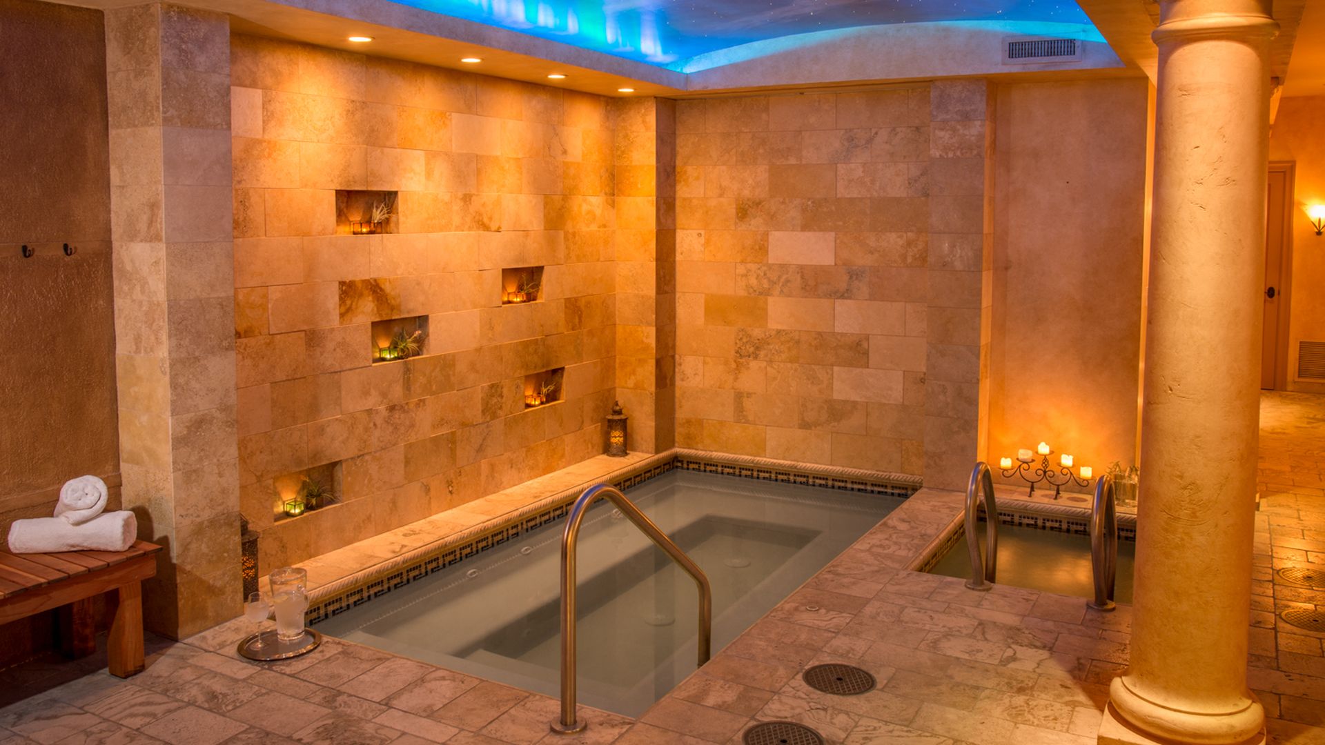 A photo of a stone tiled spa with a soaking pool.