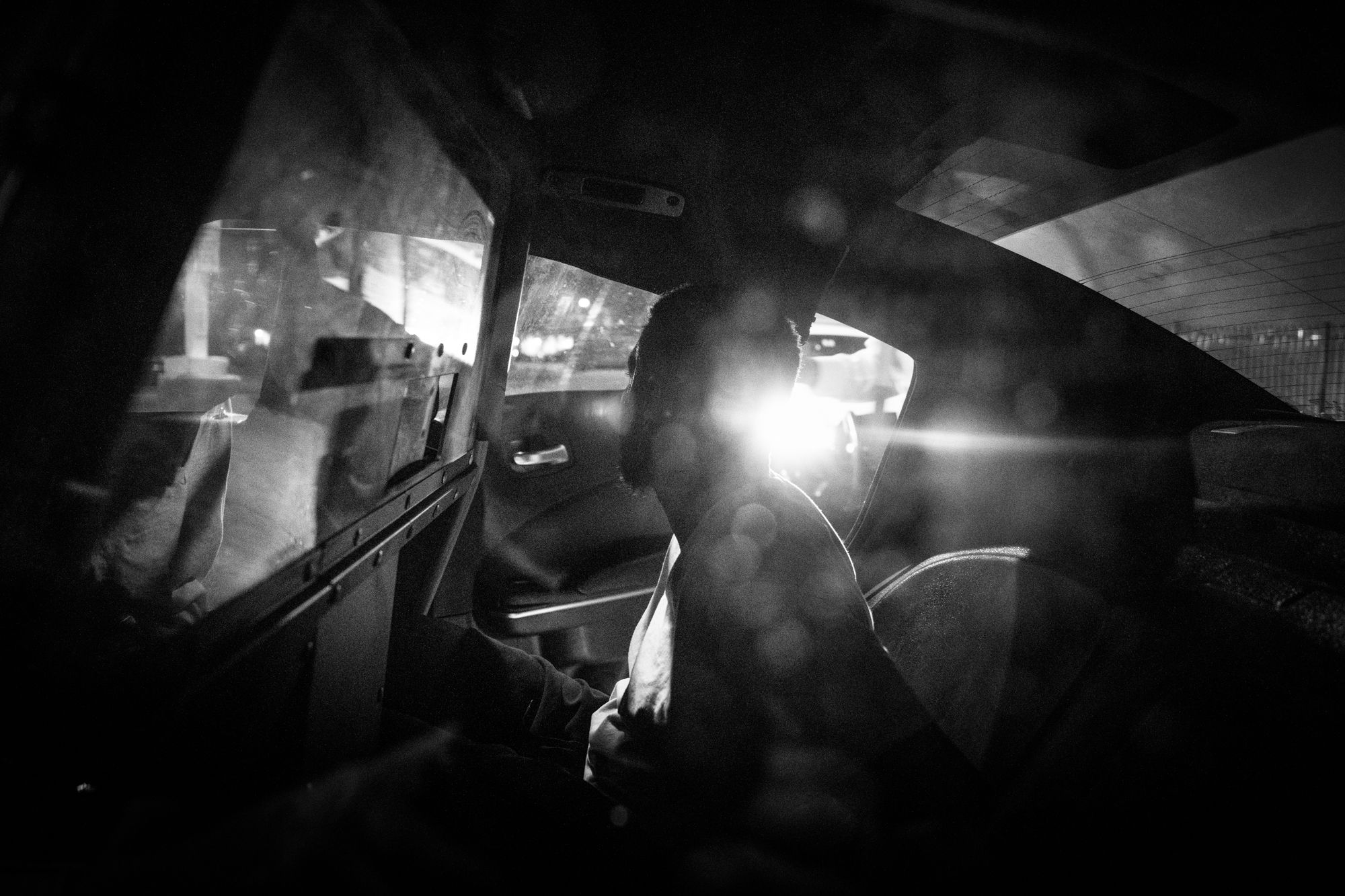 A man handcuffed in the back of a police car