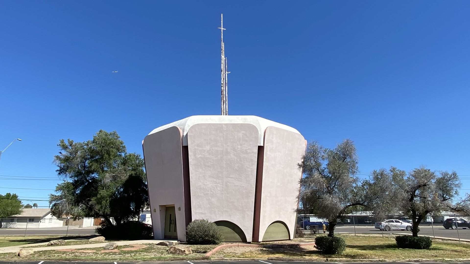 A cupcake shaped building topped by three crosses. 