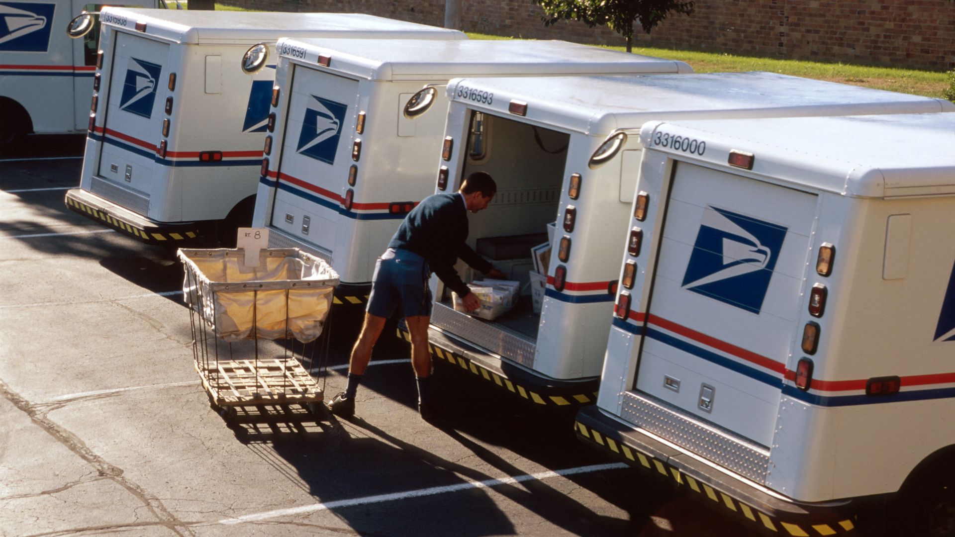 Photo of a postal worker loading a postal truck
