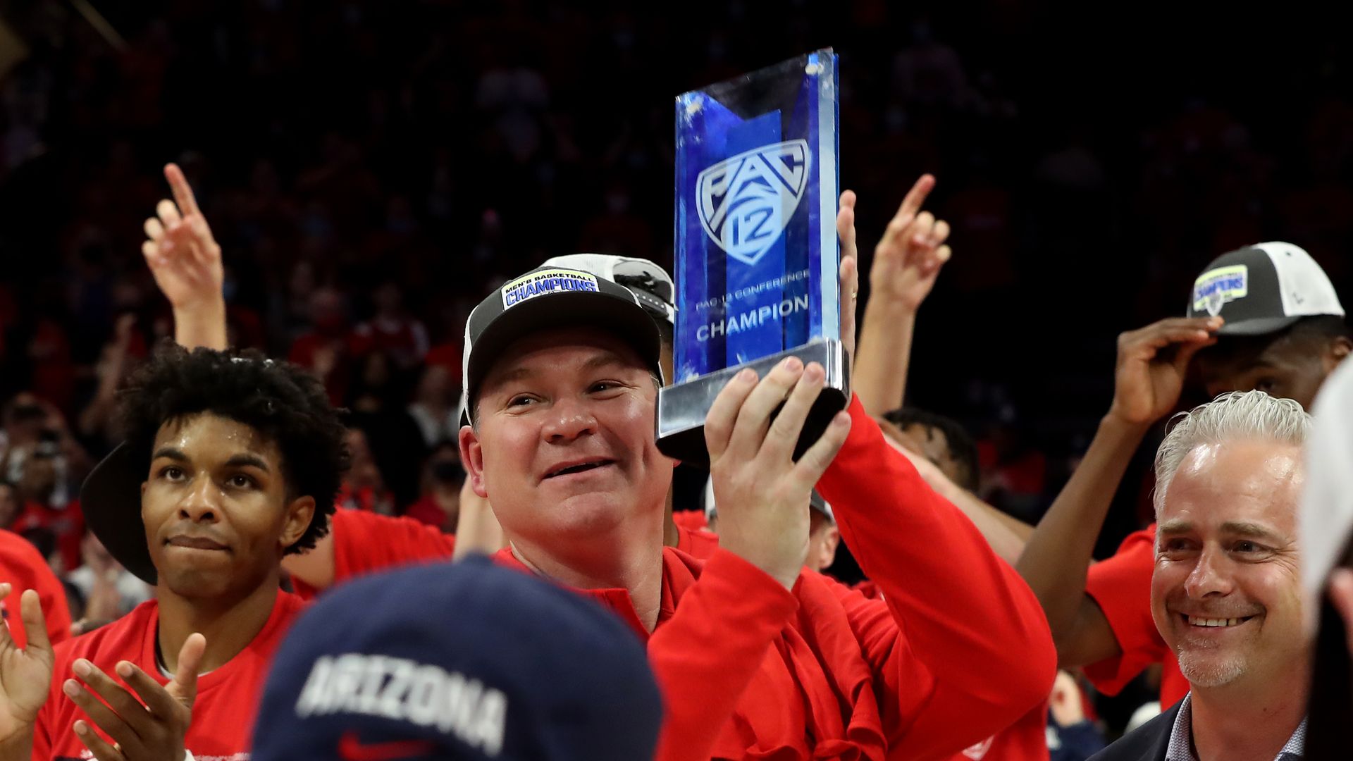 University of Arizona men's basketball coach Tommy Lloyd holds up a Pac-12 conference championship trophy