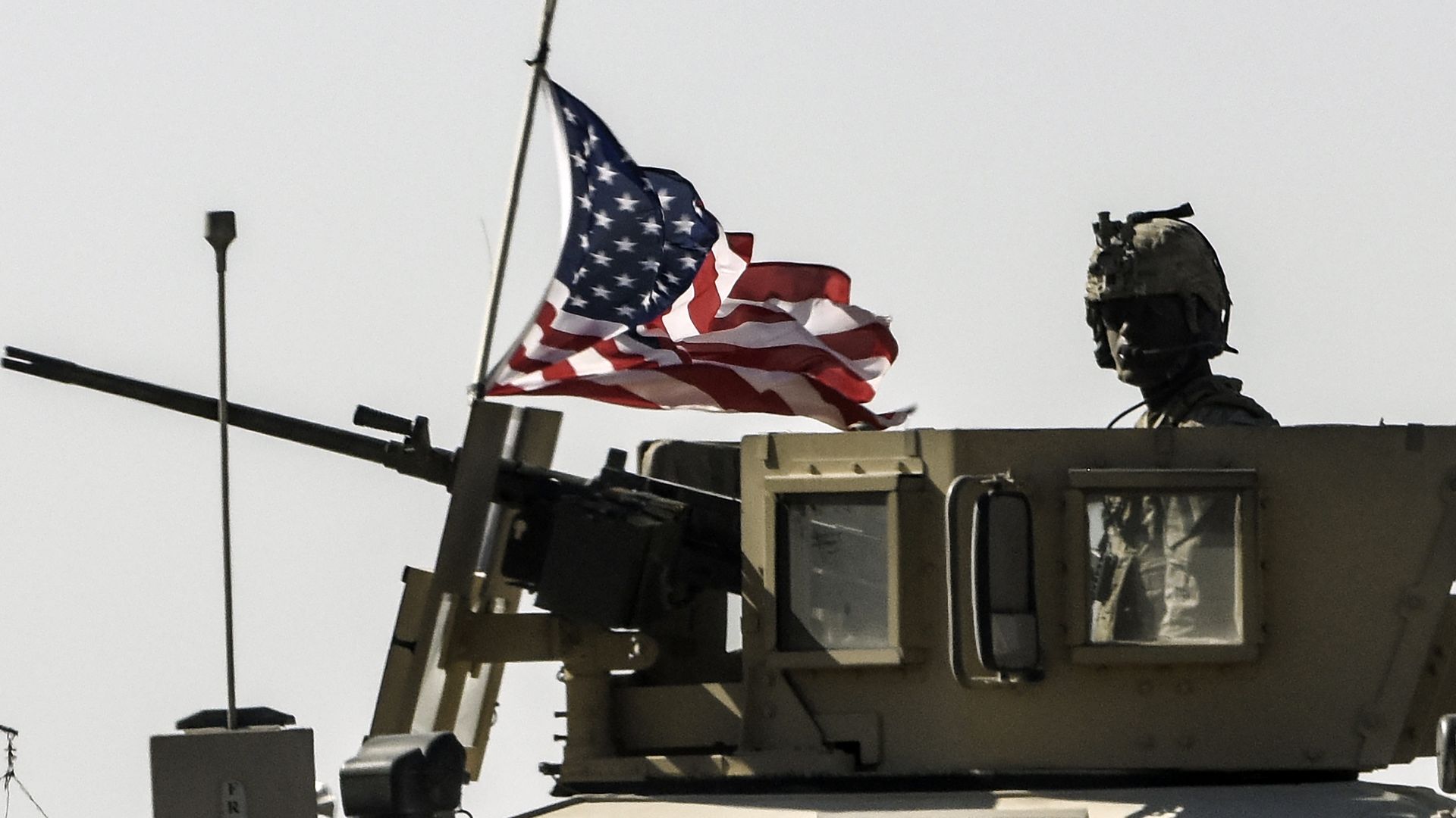 a us military convoy drives on a highway in syria.