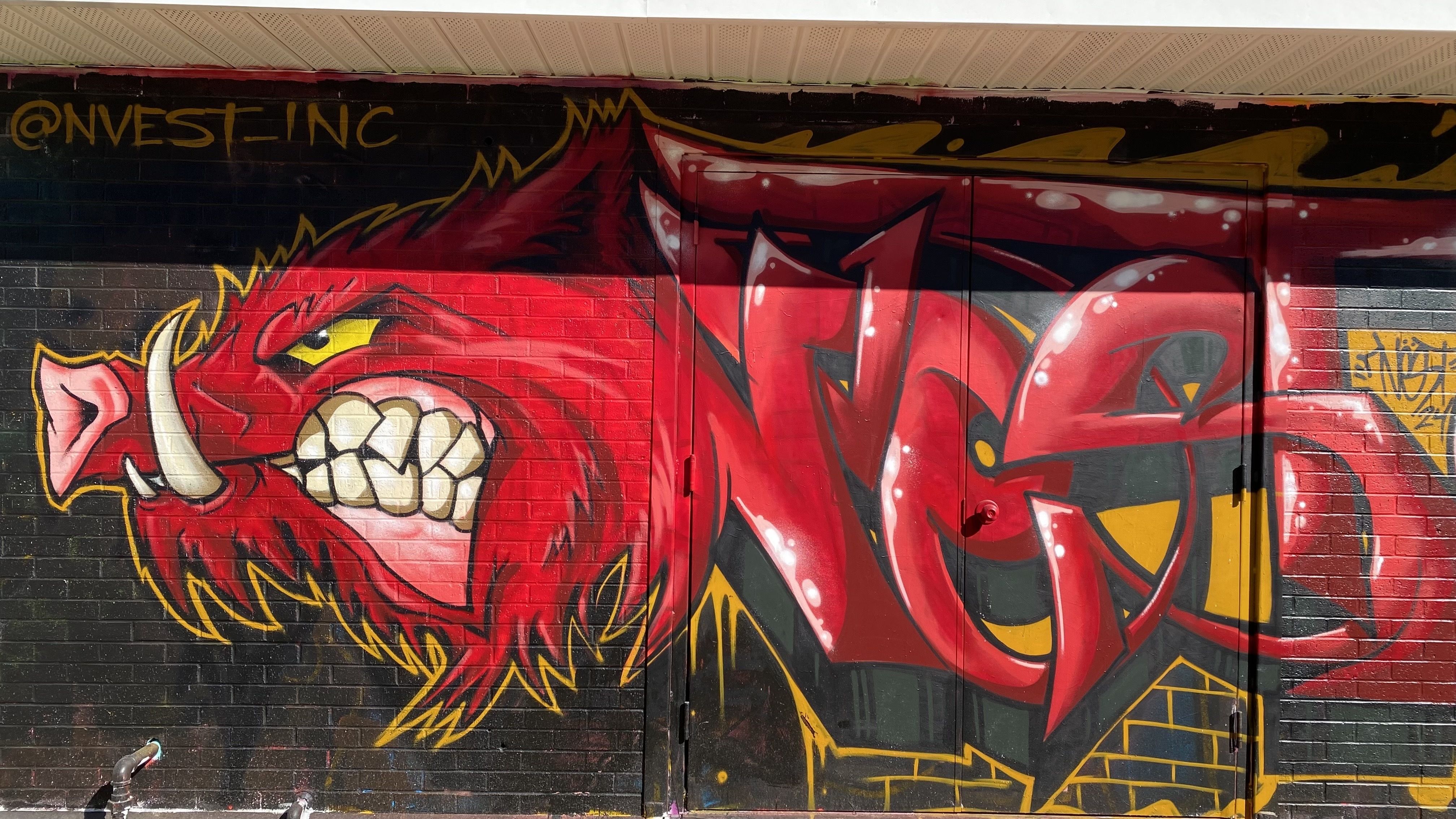 A photo of a mural of a Razorback painted on a brick wall. 