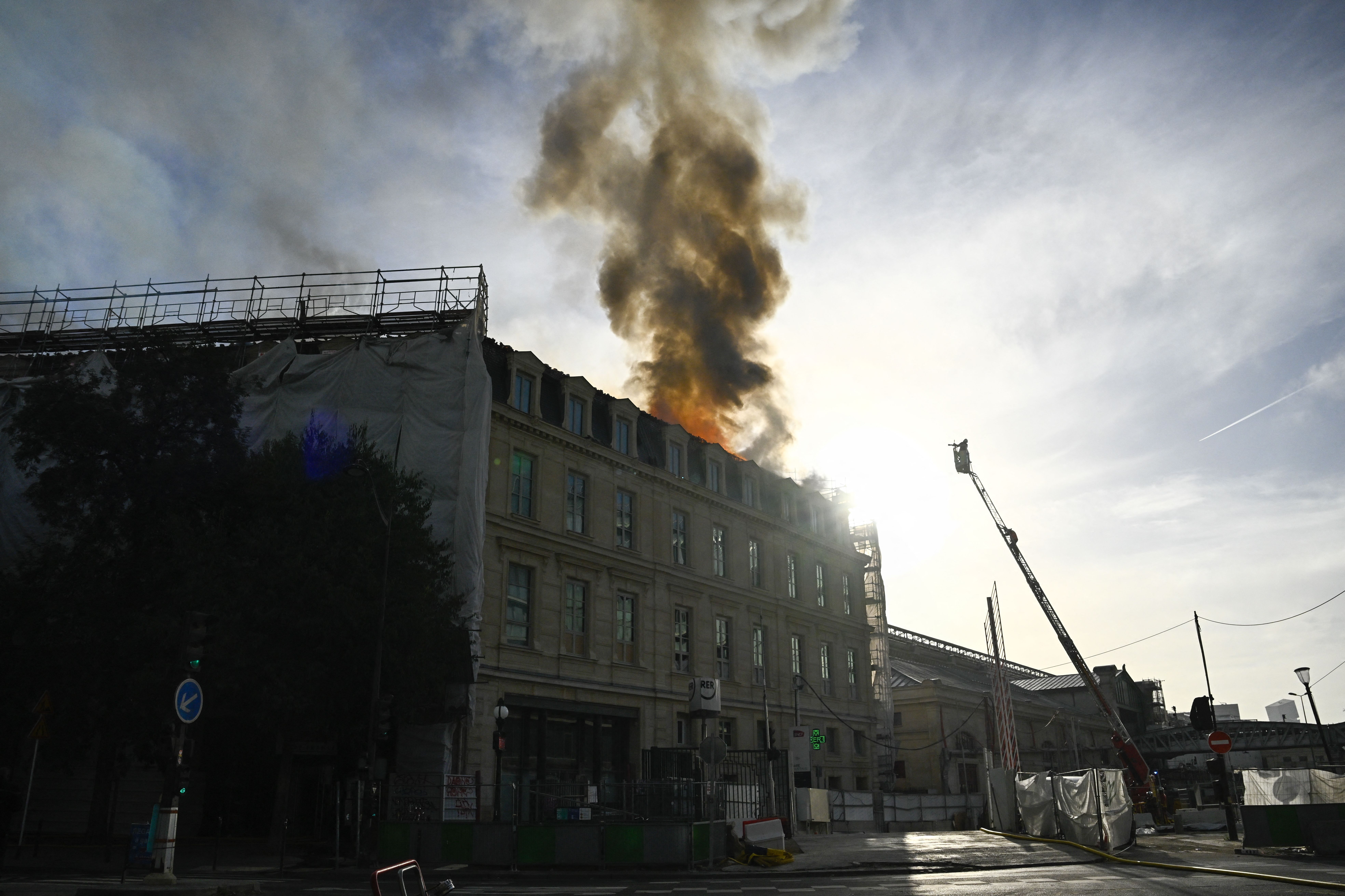 A firefighter battles a rooftop blaze near the Gare d'Austerlitz train station in Paris on Oct. 14. Photo: Julien De Rosa/AFP via Getty Images