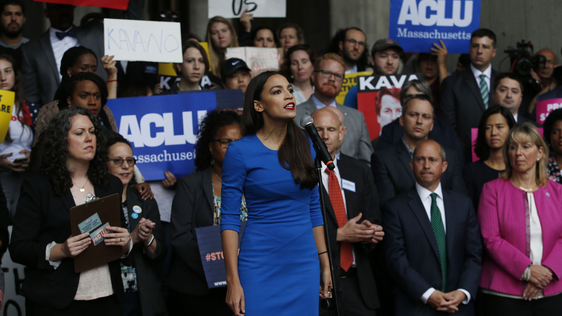 Alexandria Ocasio-Cortez stands before protestors while addressing a rally in Boston
