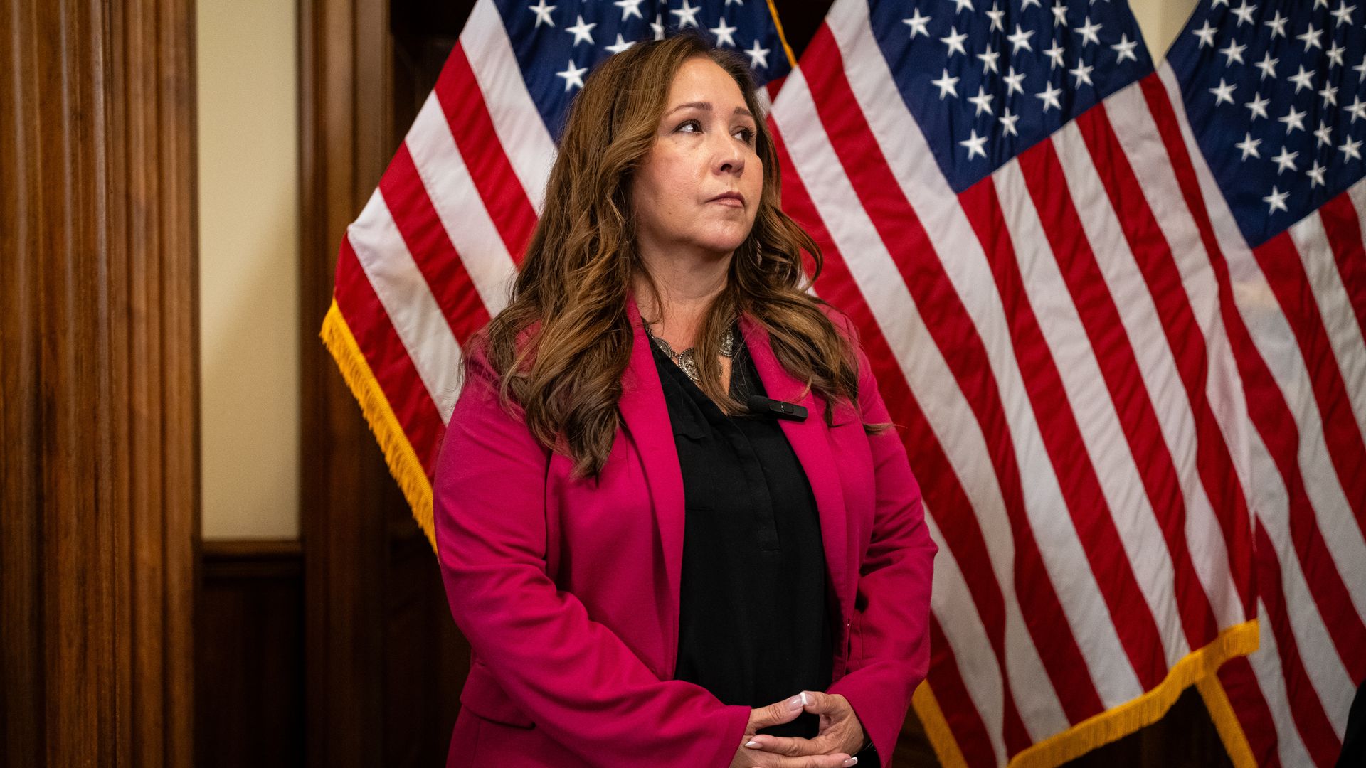 Grijalva at a news conference with American flags behind her looking off to the right 