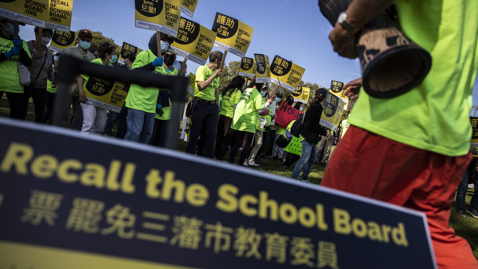 Photo of a crowd of Asian protesters holding signs that say "Recall the School Board" in English and Chinese