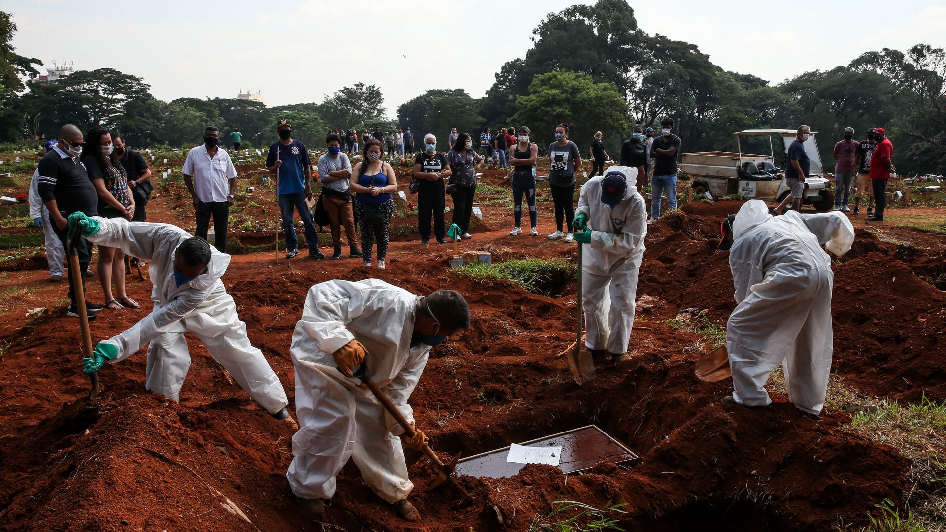 Cemetery workers bury a victim of coronavirus (COVID-19) as family members attend the funeral at Vila Formosa Cemetery on March 12, 2021 in Sao Paulo, Brazil. 