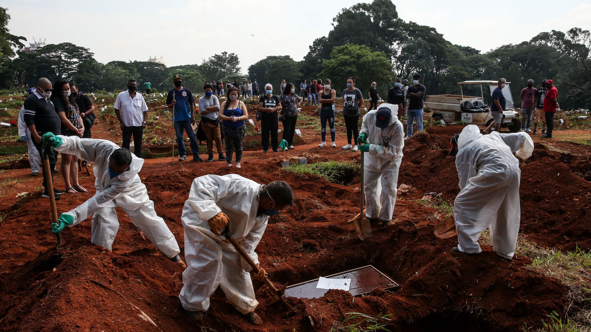 Cemetery workers bury a victim of coronavirus (COVID-19) as family members attend the funeral at Vila Formosa Cemetery on March 12, 2021 in Sao Paulo, Brazil.