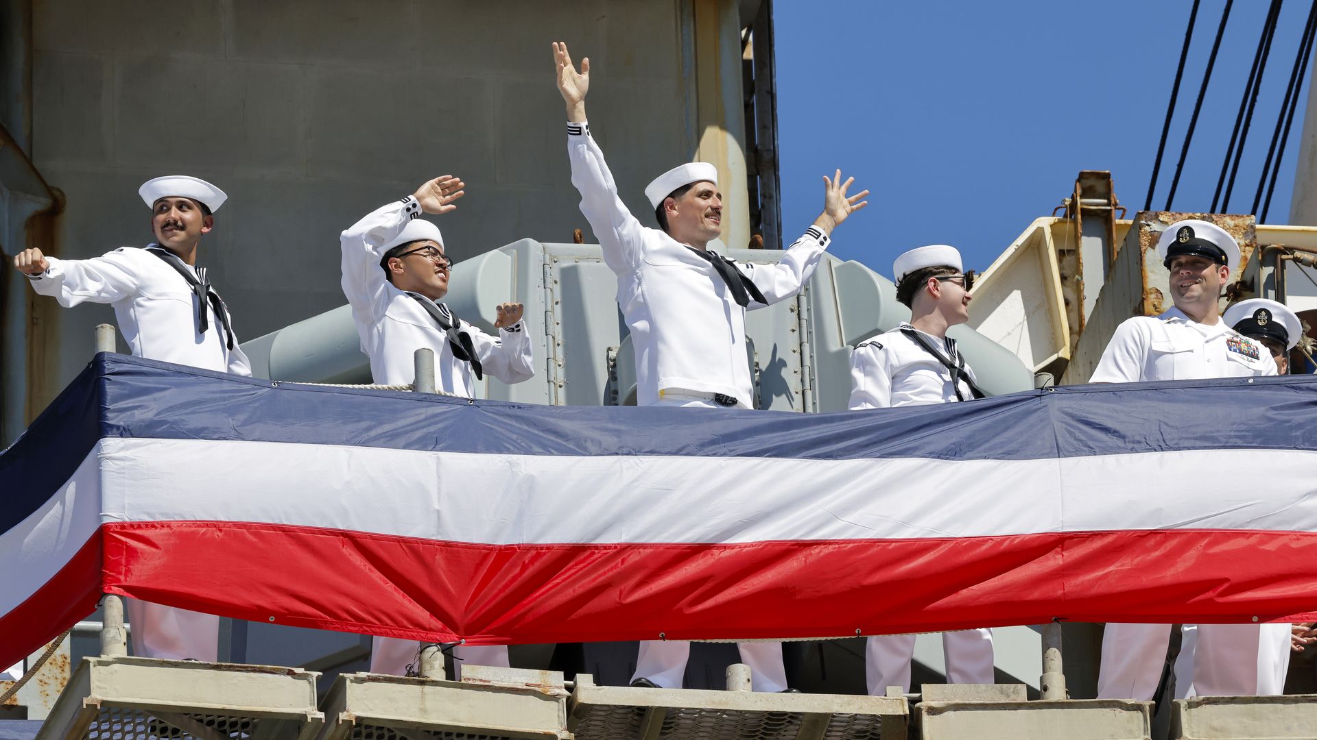 CORONADO, CALIFORNIA - OCTOBER 08: Sailors aboard the USS Abraham Lincoln Nimitz-class aircraft carrier wave to friends and family members as the ship docks at its homeport at Naval Air Station North Island on return from a historic 10-month deployment on October 8, 2026 in Coronado, California. The