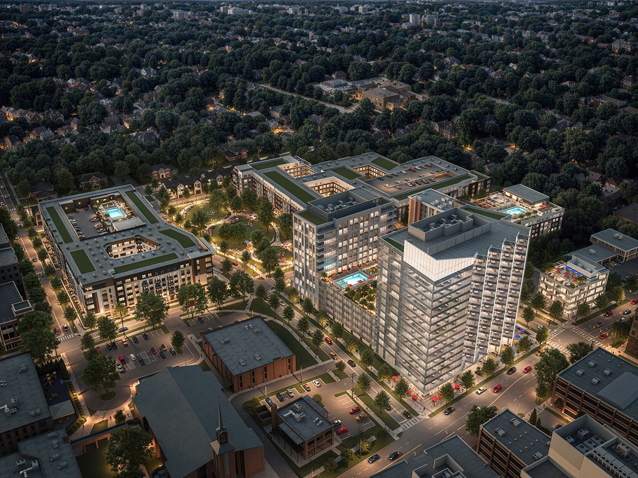 Aerial view of a modern, multi-building residential complex with rooftop pools, glass façades, green courtyards, and tree-lined streets, set in a suburban neighborhood at dusk.