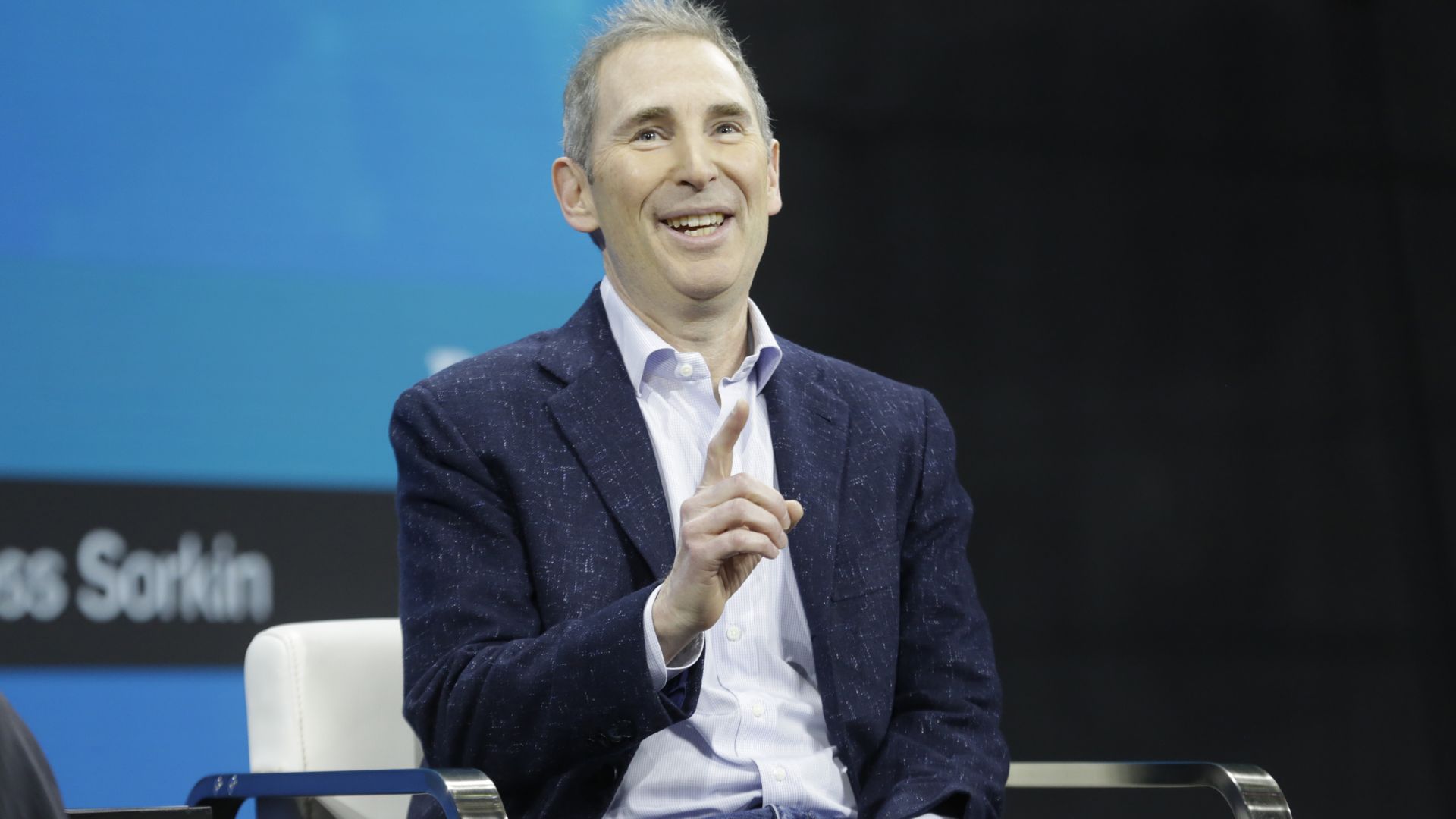 photo of a man in a suit with his pointer finger up in the air