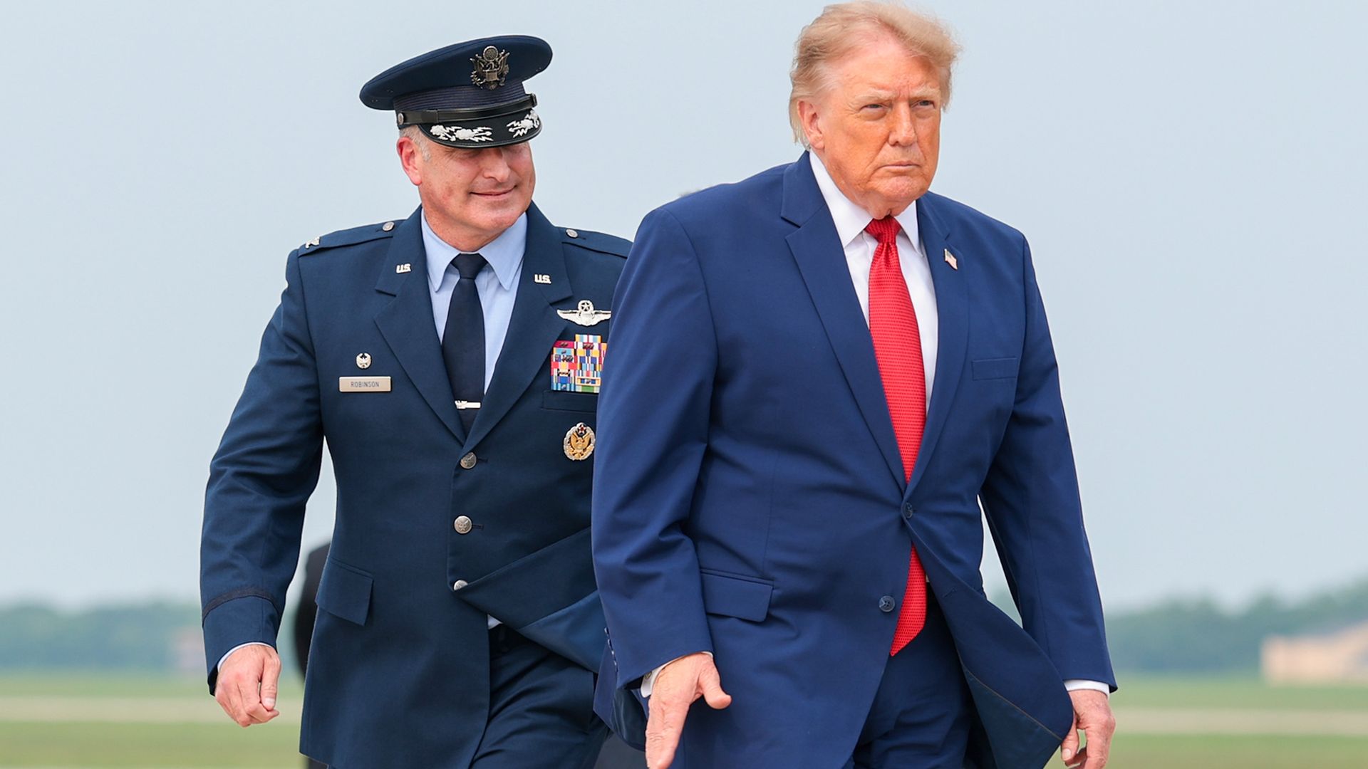 U.S. President Donald Trump is accompanied by U.S. Air Force Col. Christopher M. Robinson (L) as he walks to board Air Force One on August 11, 2026 at Joint Base Andrews, Maryland.