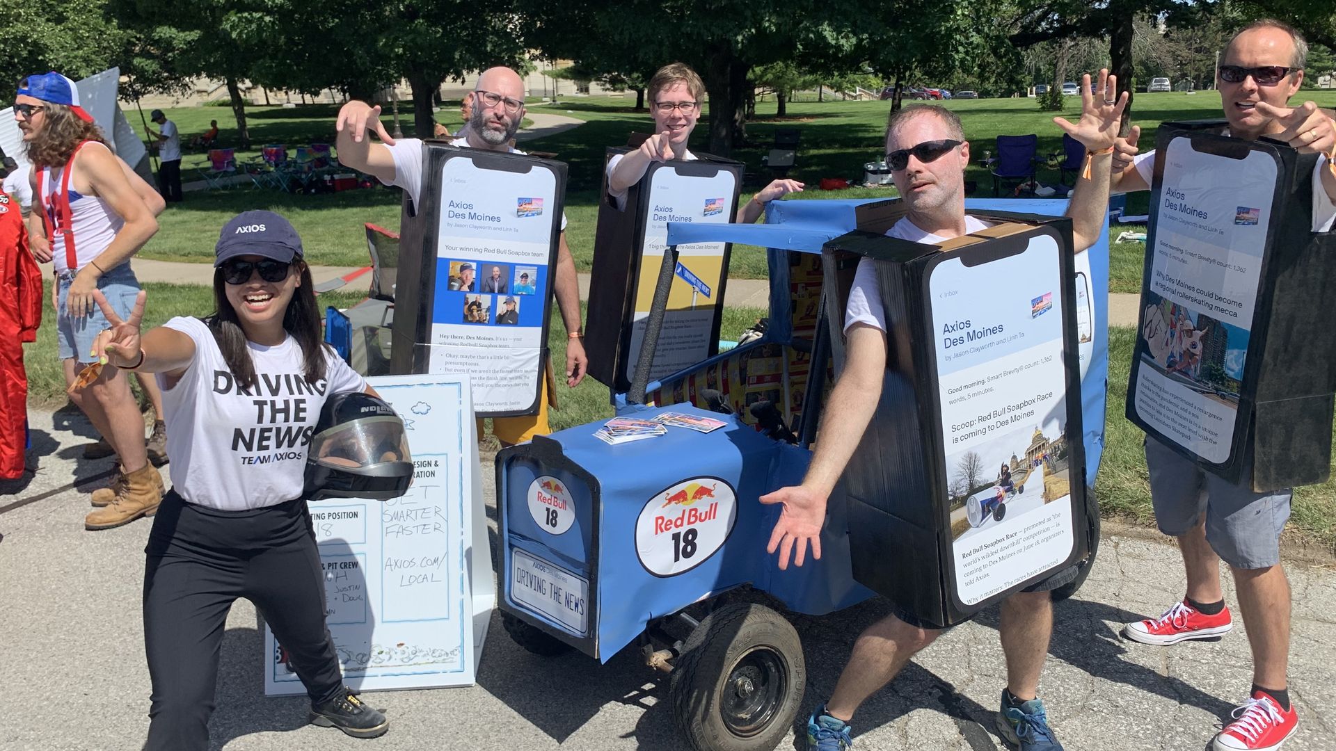 Photo of a team in front of a race car.