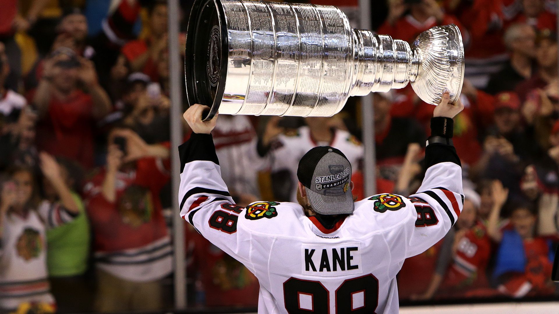 hockey player holding a big silver cup 