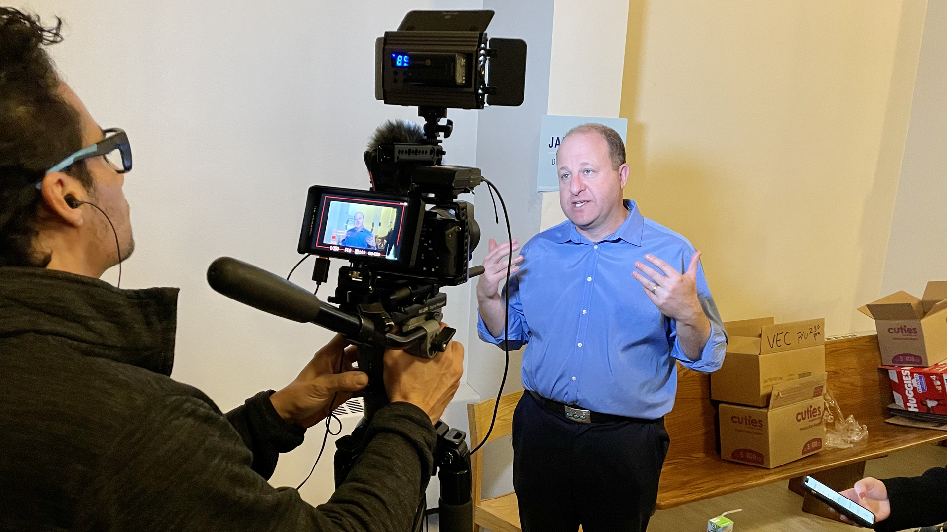 Gov. Jared Polis speaks to a Spanish-language TV station at a campaign kickoff event Wednesday in Aurora. Photo: John Frank/Axios
