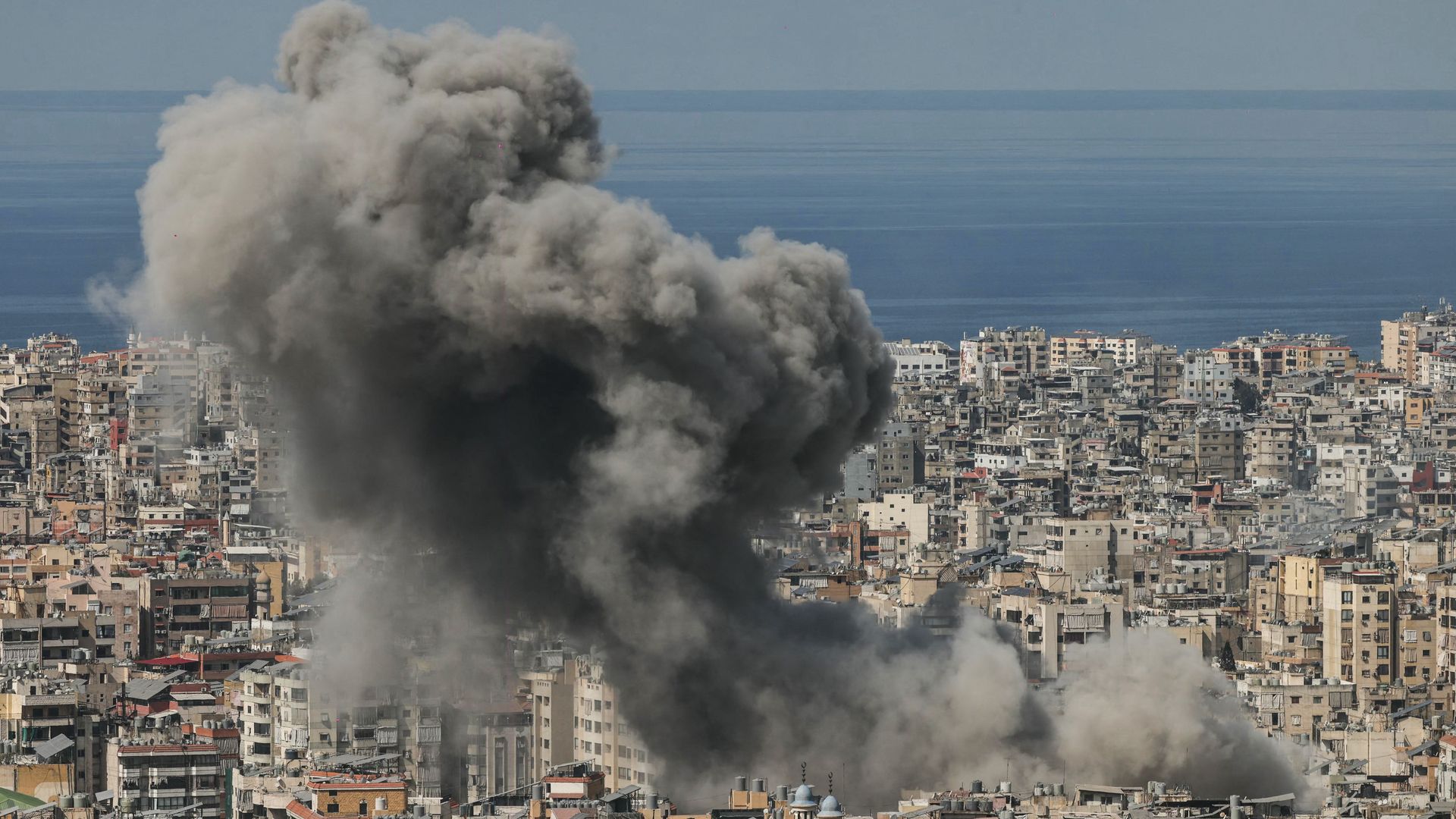 Thick smoke rises over buildings in Beirut’s southern suburbs following an Israeli airstrike as regional conflict intensifies.