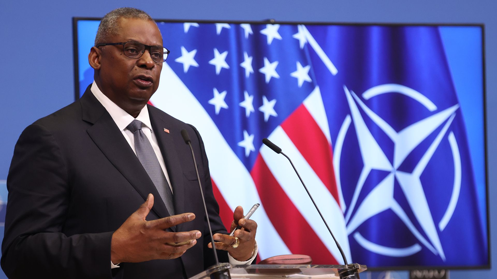 Photo of Lloyd Austin gesturing while speaking from a podium