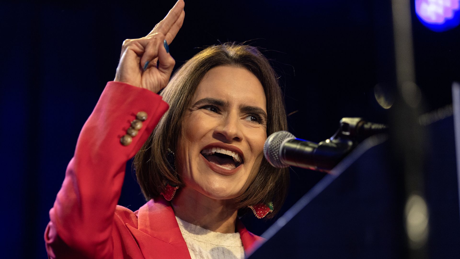 Minnesota Lt. Gov. Peggy Flanagan, wearing a red jacket, speaks into a microphone.