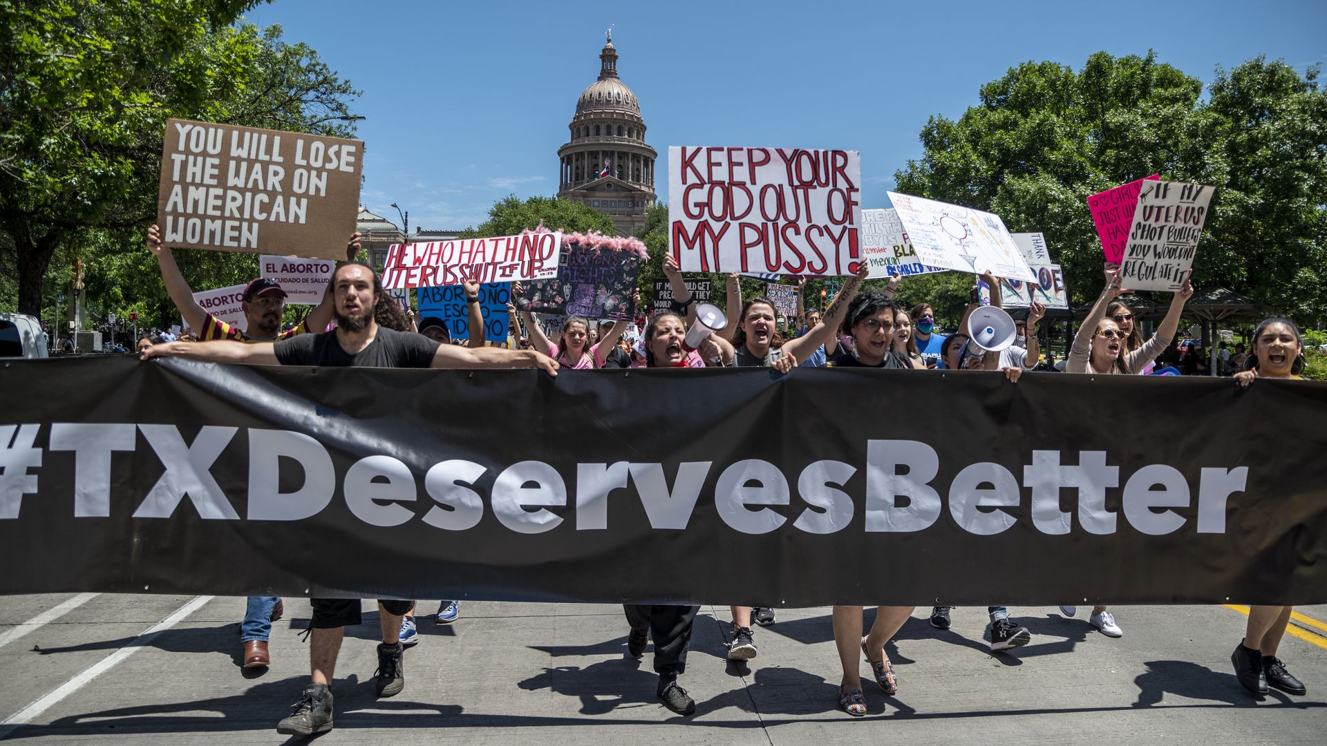 Picture of pro-choice protesters holding a banner that says #TXDeservesBetter