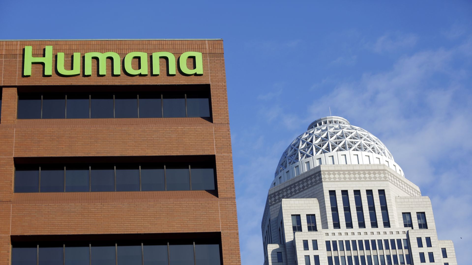 A green Humana sign on a brown headquarters building.