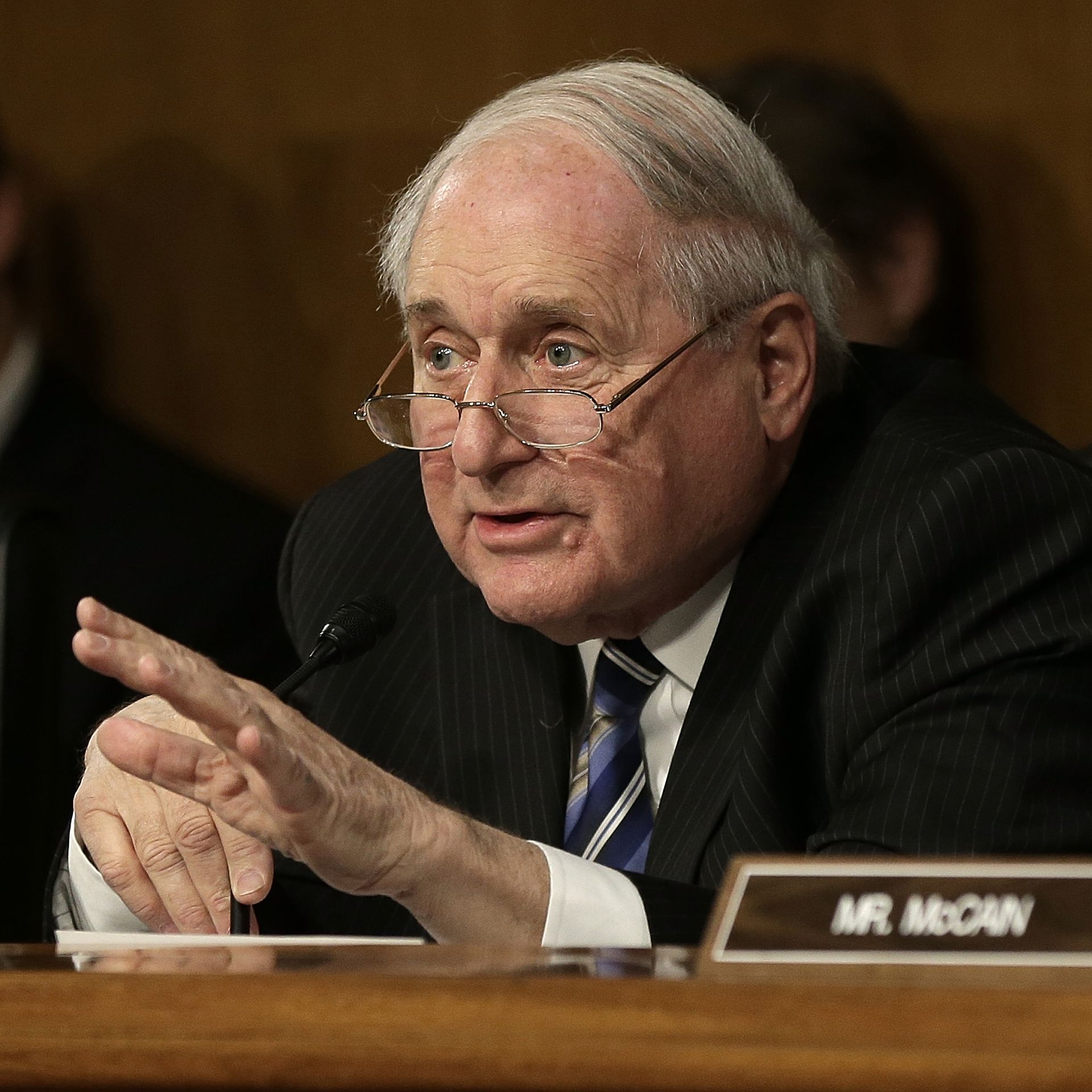 Sen. Carl Levin gestures while seated at a podium