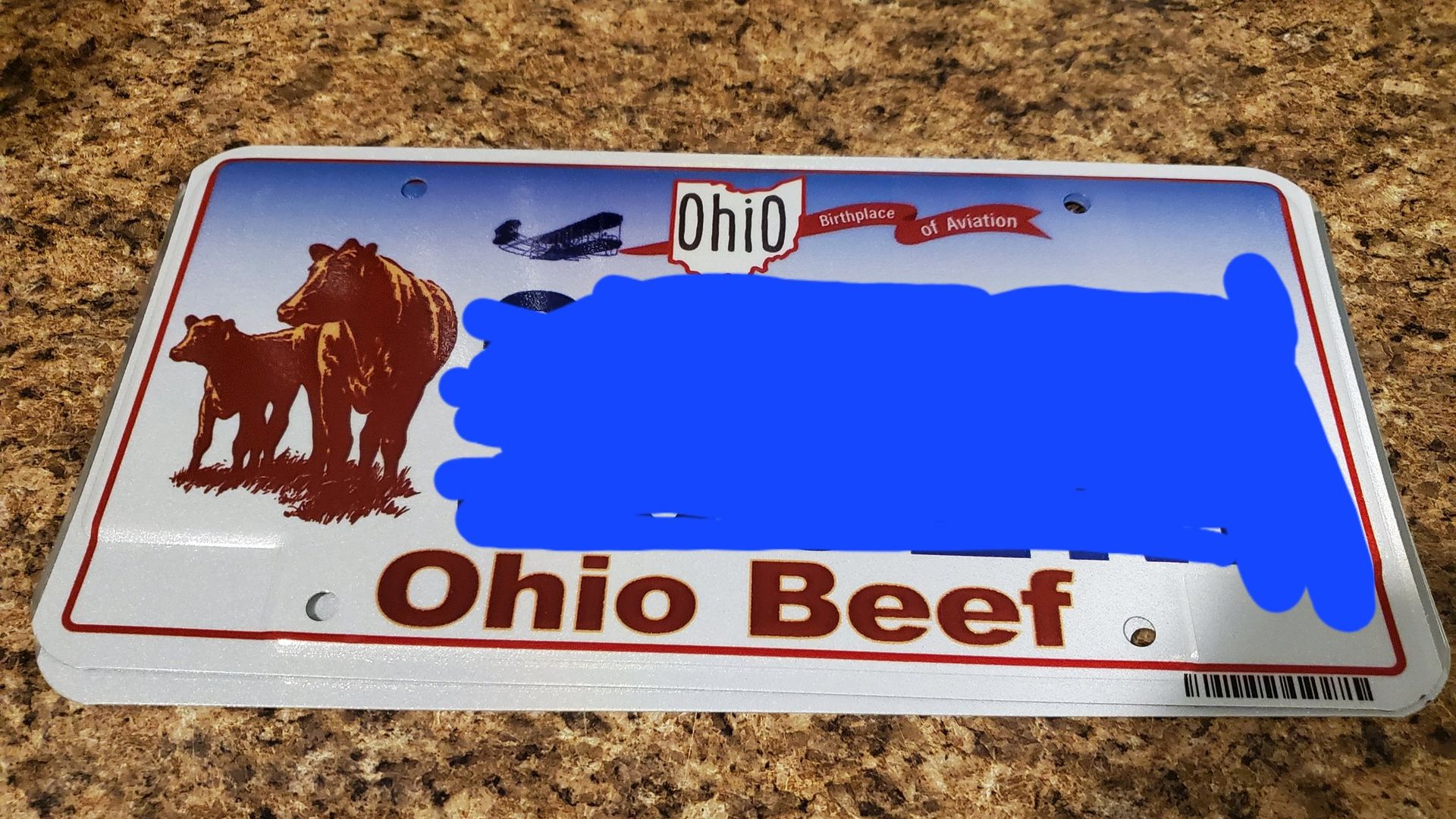 An Ohio license plate with cows on it reading "Ohio Beef."