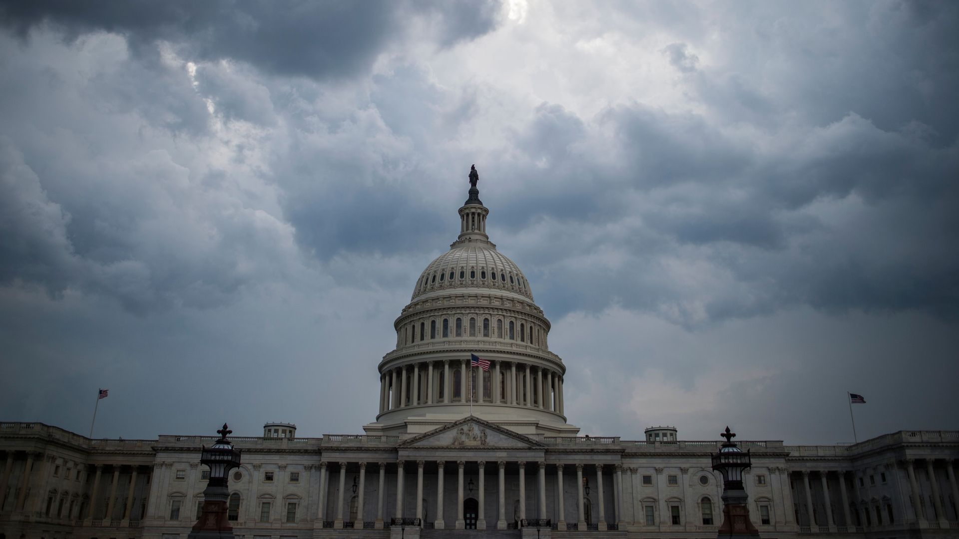 Capitol Hill dome with white and dark blue clouds above.