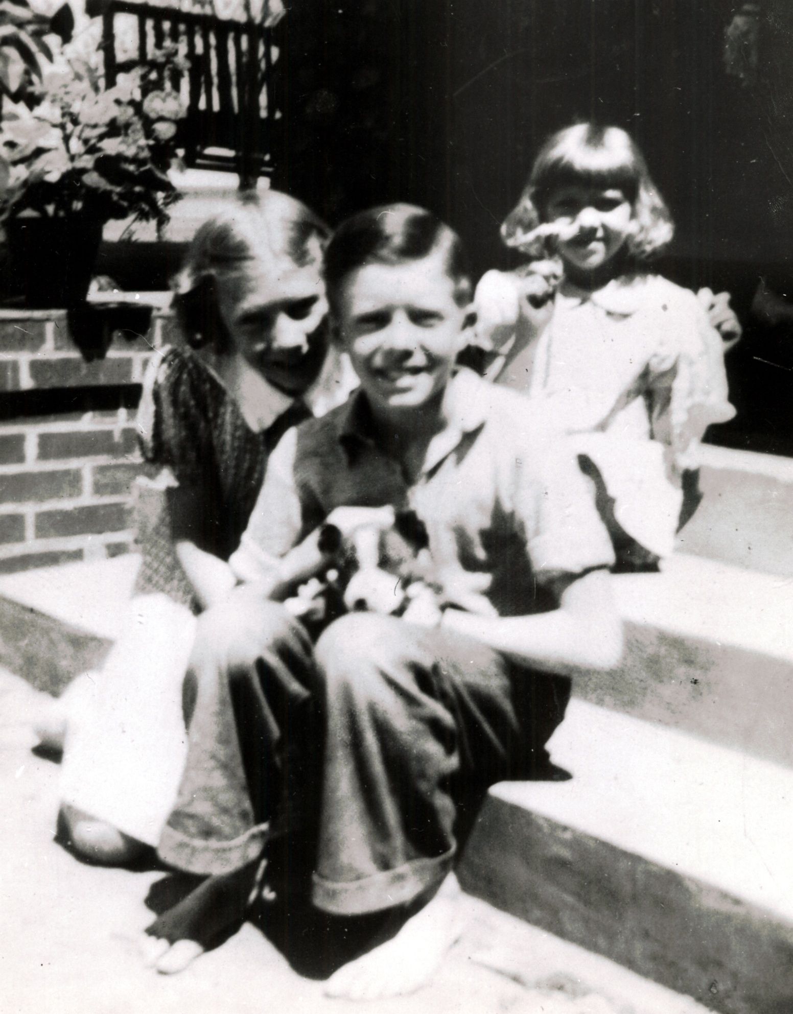 Jimmy Carter at 12 years old, surrounded by his sisters Gloria and Ruth. Ruth is holding a flower over his shoulder