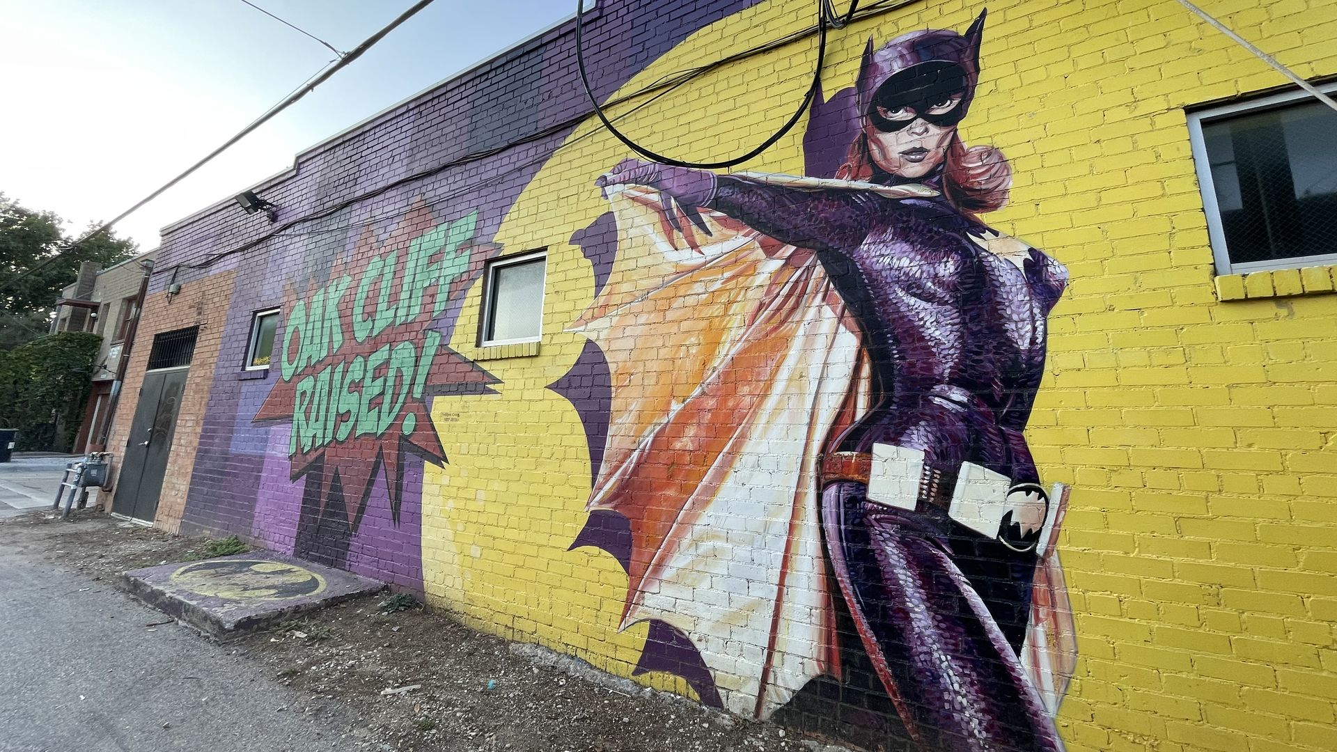 A mural of Batgirl next to the words "OAK CLIFF RAISED!"