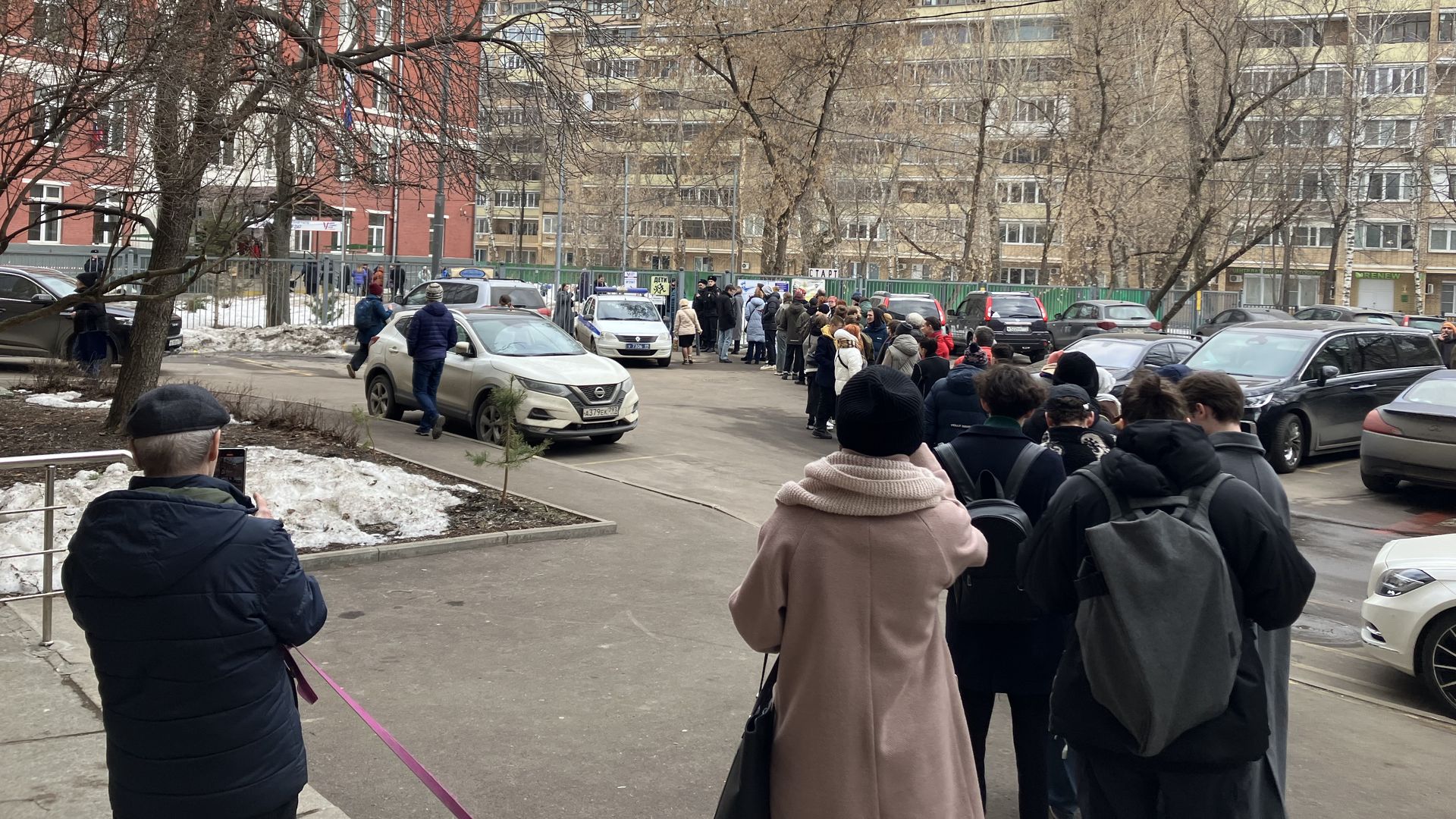People wait in line outside a polling station in Moscow