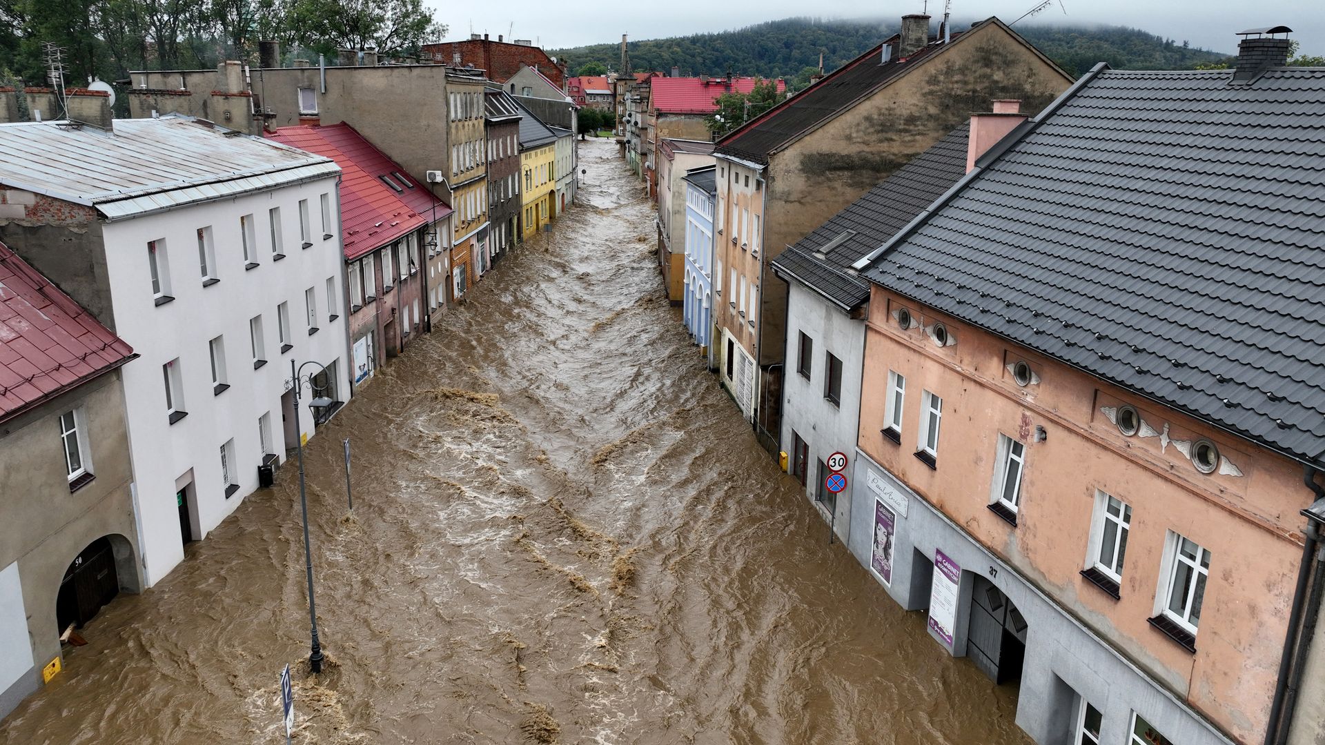 Floodwaters are seen flowing along a road in a European town. 