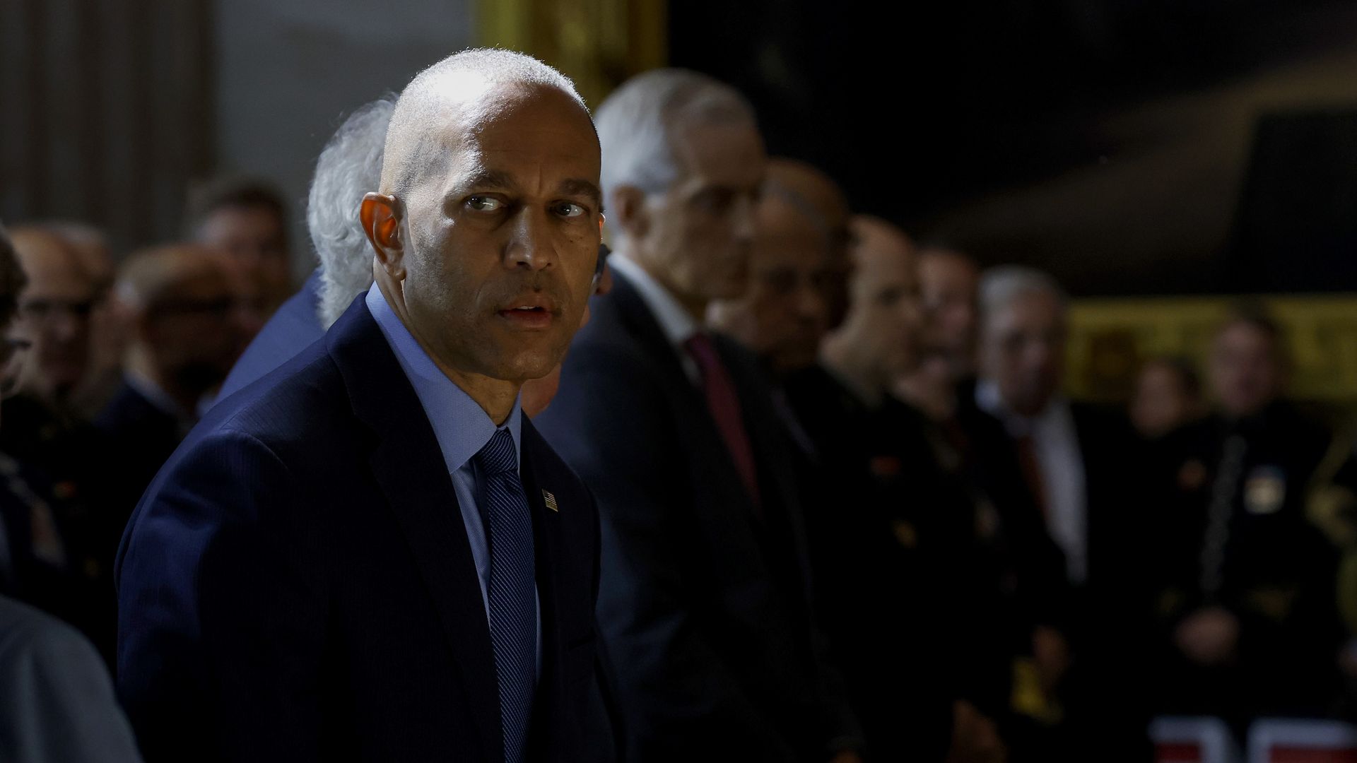 Hakeem Jeffries, wearing a blue suit and standing in a line of people in the Capitol rotunda.
