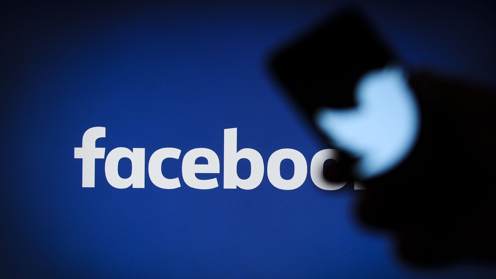 An illustration of a screen with the Facebook logo and a phone with a Twitter logo