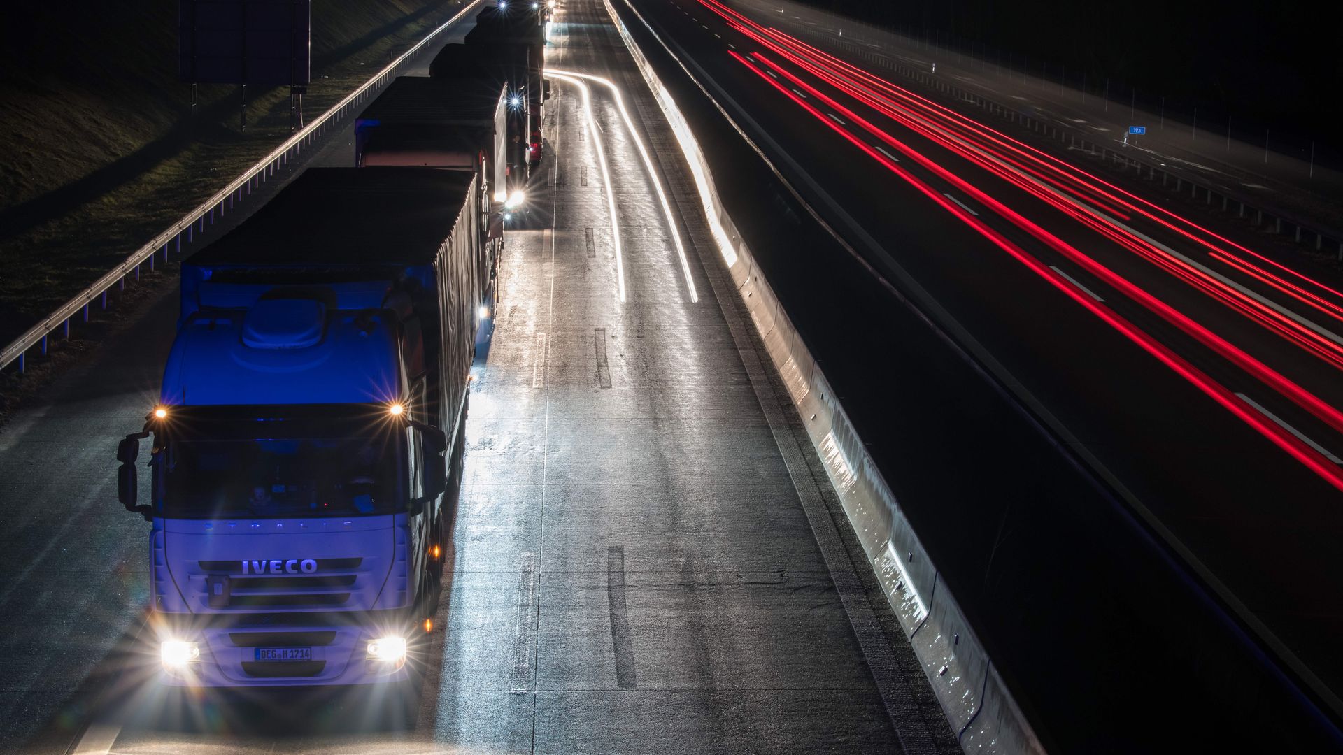 Trucks in a line in traffic at night