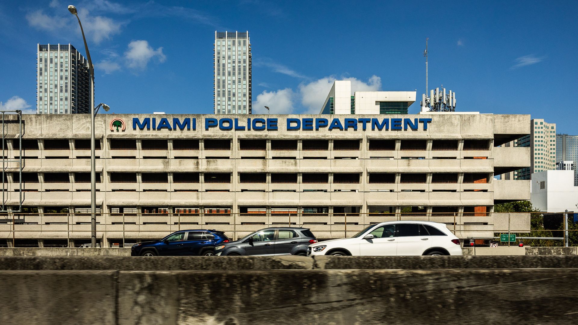 View of the Miami Police Department building and cars from the road