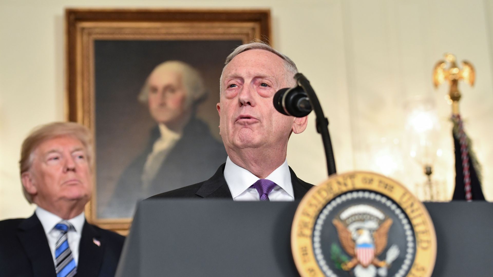 President Trump looks with concern at Secretary of Defense Jim Mattis as Mattis speaks at a podium.