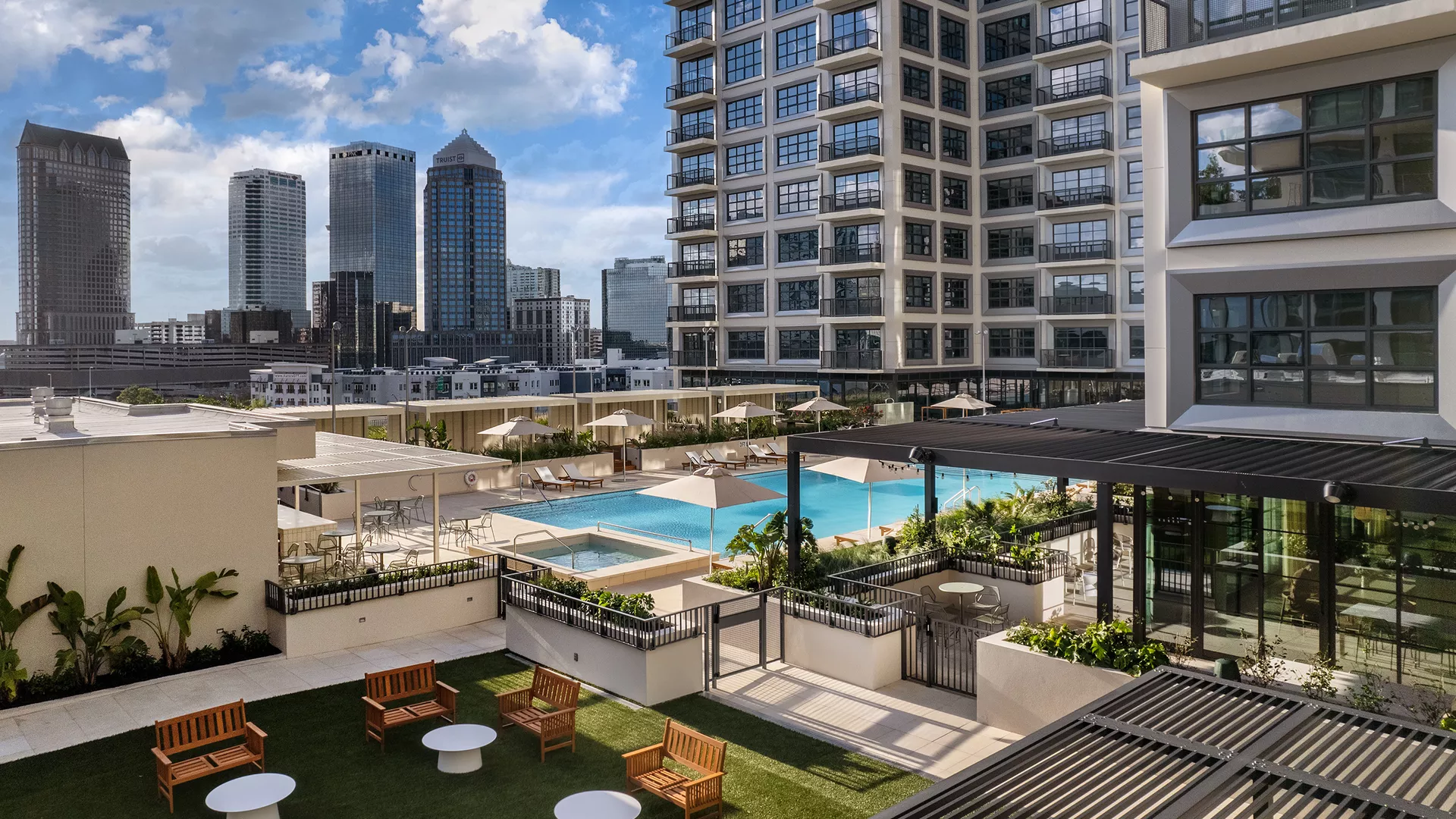 A rooftop pool with a turf lounge area on the roof of Asher