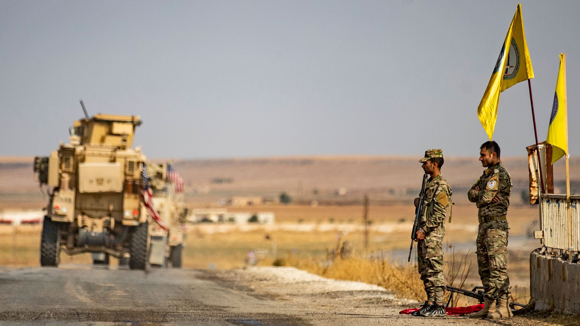US military vehicles drive on a road in the town of Tal Tamr on October 20, 2019, after pulling out of their base. 