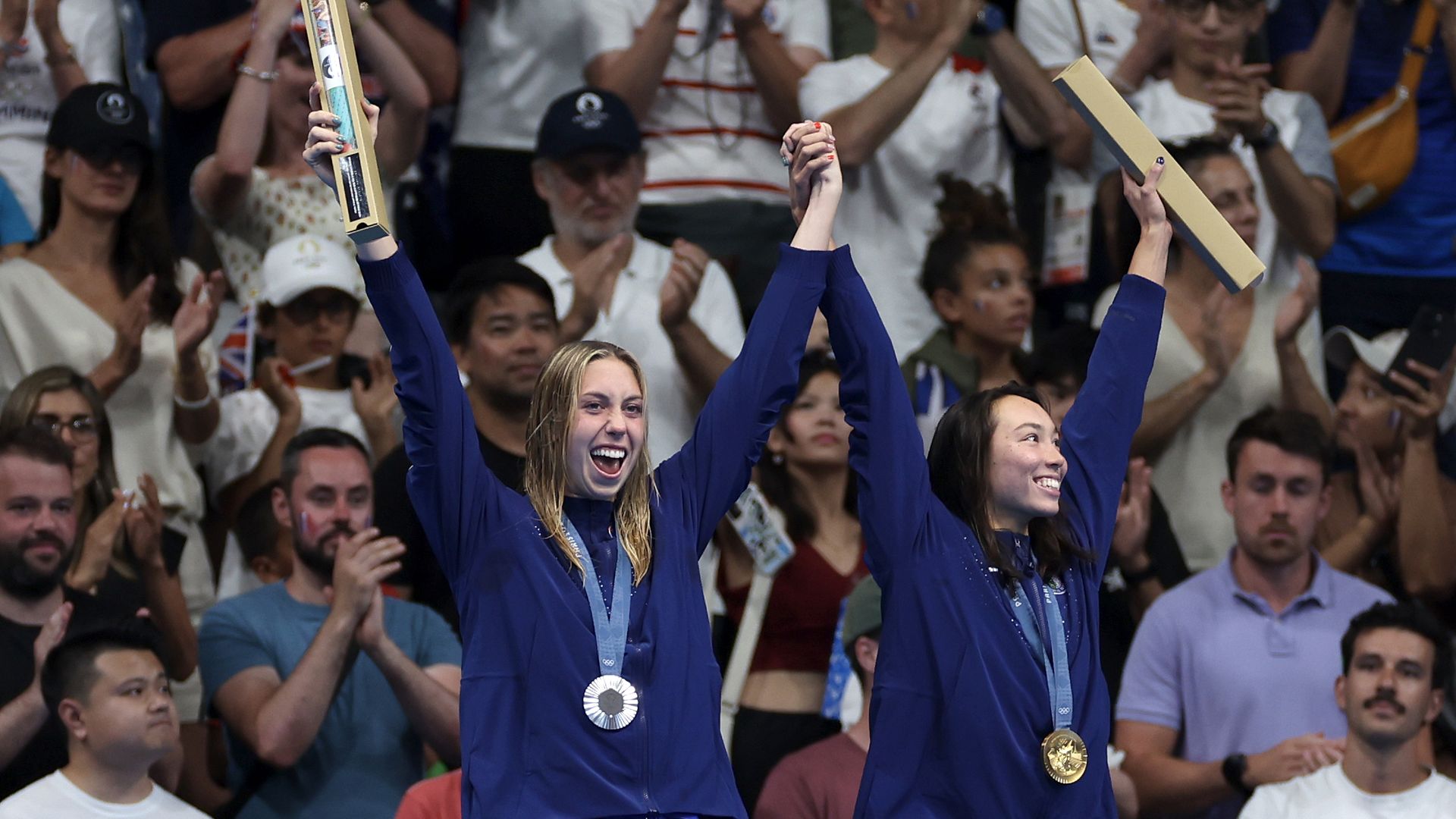 Gold Medalist Torri Huske (R) and Silver Medalist Gretchen Walsh (L) of Team United States celebrate on the podium during the Swimming medal ceremony after the Women’s 100m Butterfly Final on day two of the Olympic Games Paris 2024 