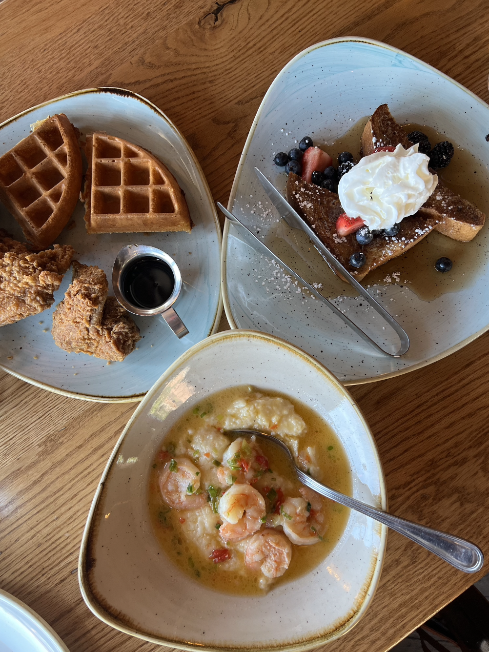 A brunch spread with chicken and waffles, shrimp and grits, and French toast.