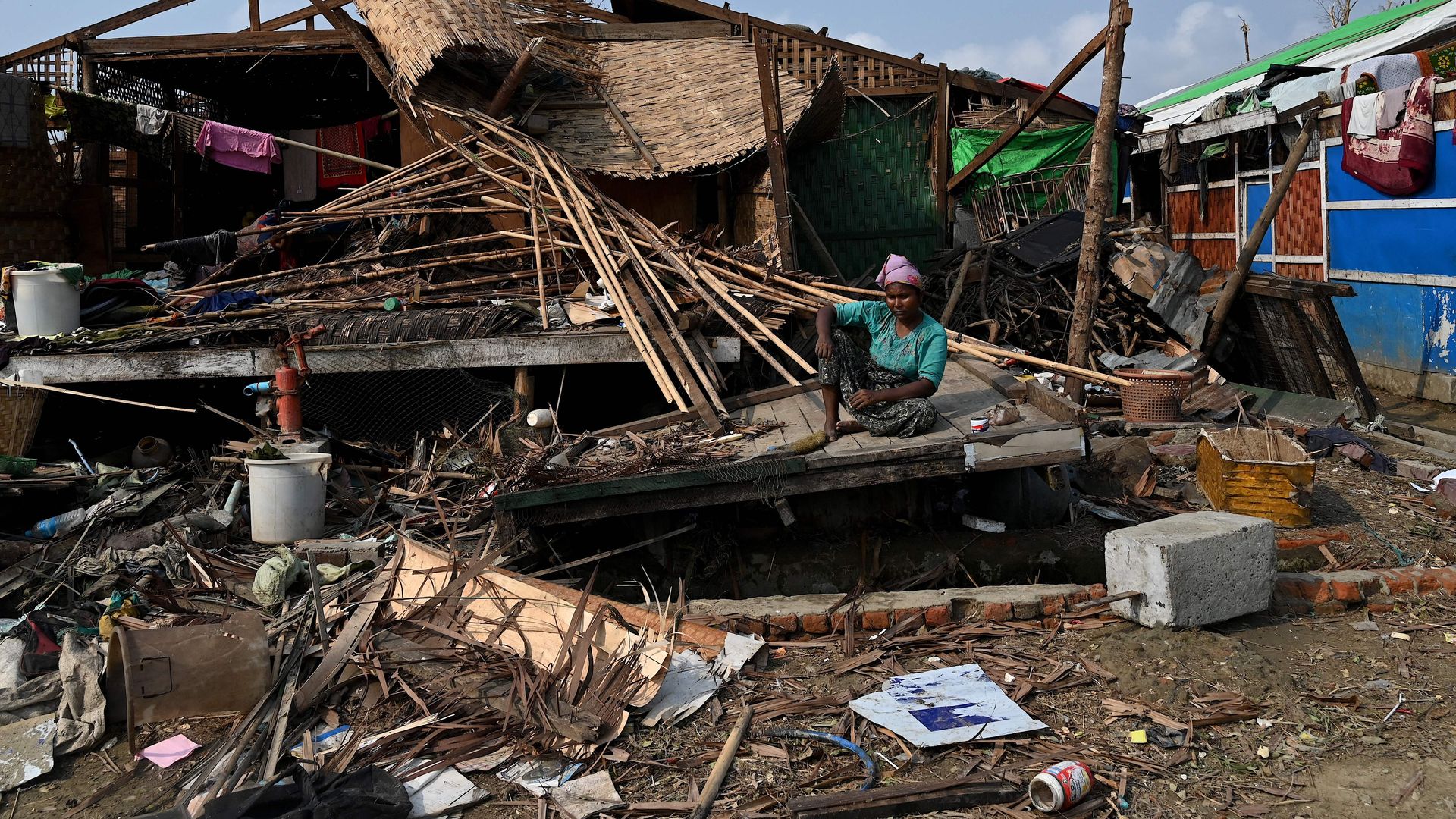 A Rohingya woman sits by her destroyed house at Ohn Taw Chay refugee camp in Sittwe, Myanmar, on May 16, in the aftermath of Cyclone Mocha's landfall.